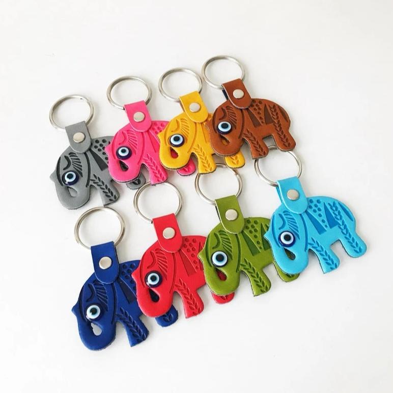 A beautifully crafted Elephant evil eye keychain featuring suede leather, resin evil eye beads, and a silver keychain hook, available in various colors.