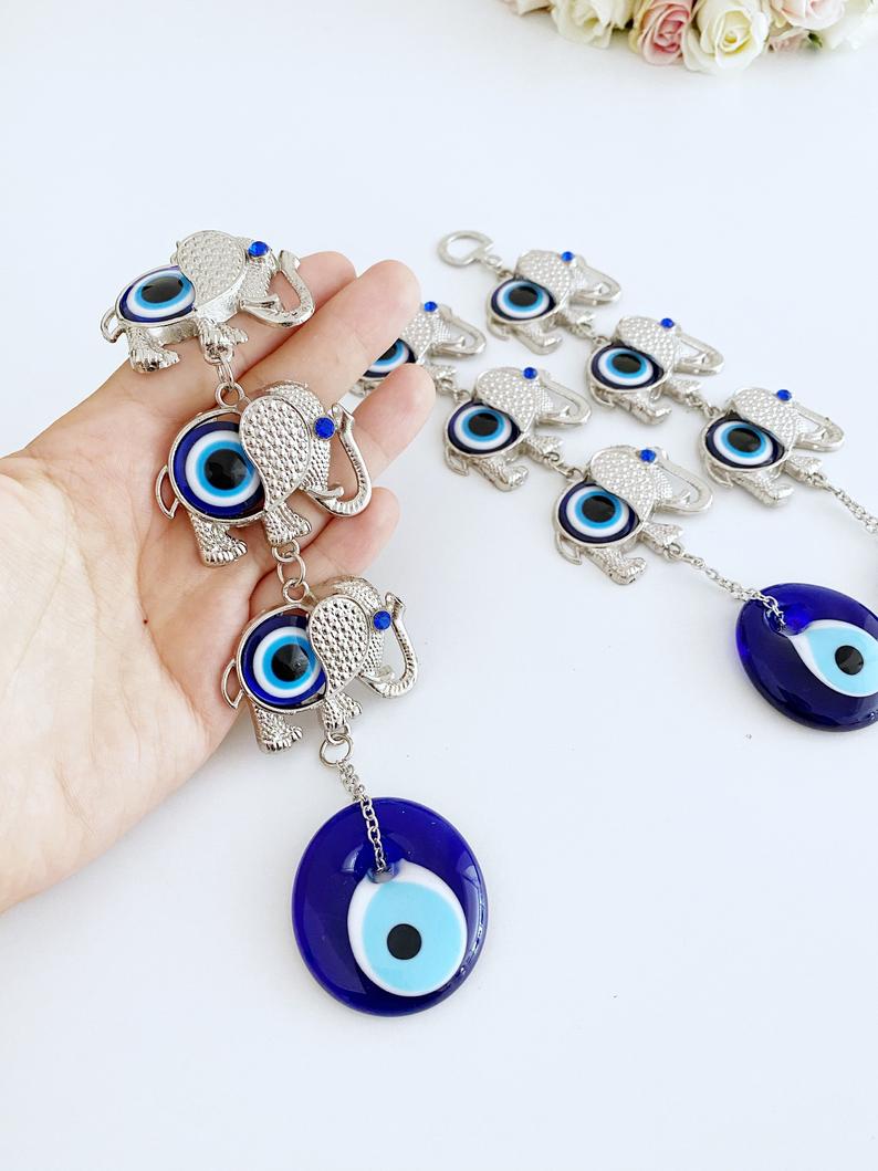 Handmade Elephant Evil Eye Wall Hanging featuring a blue evil eye charm, symbolizing good luck and protection, perfect for home decor.