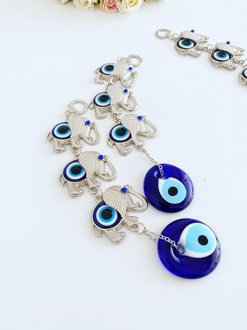 Handmade Elephant Evil Eye Wall Hanging featuring a blue evil eye charm, symbolizing good luck and protection, perfect for home decor.