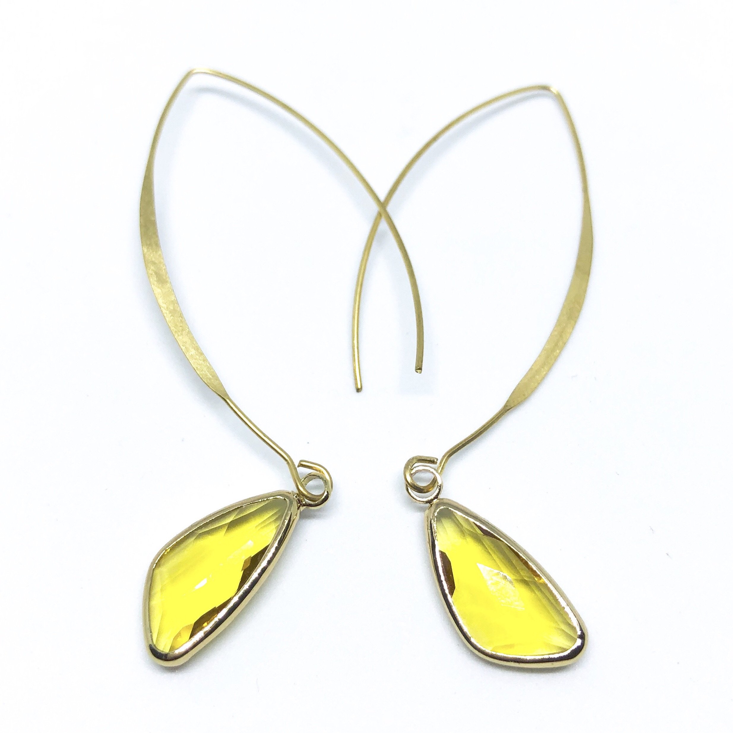 Elise Arc Earrings in gold and silver, showcasing their elegant dangle design and vibrant color options.