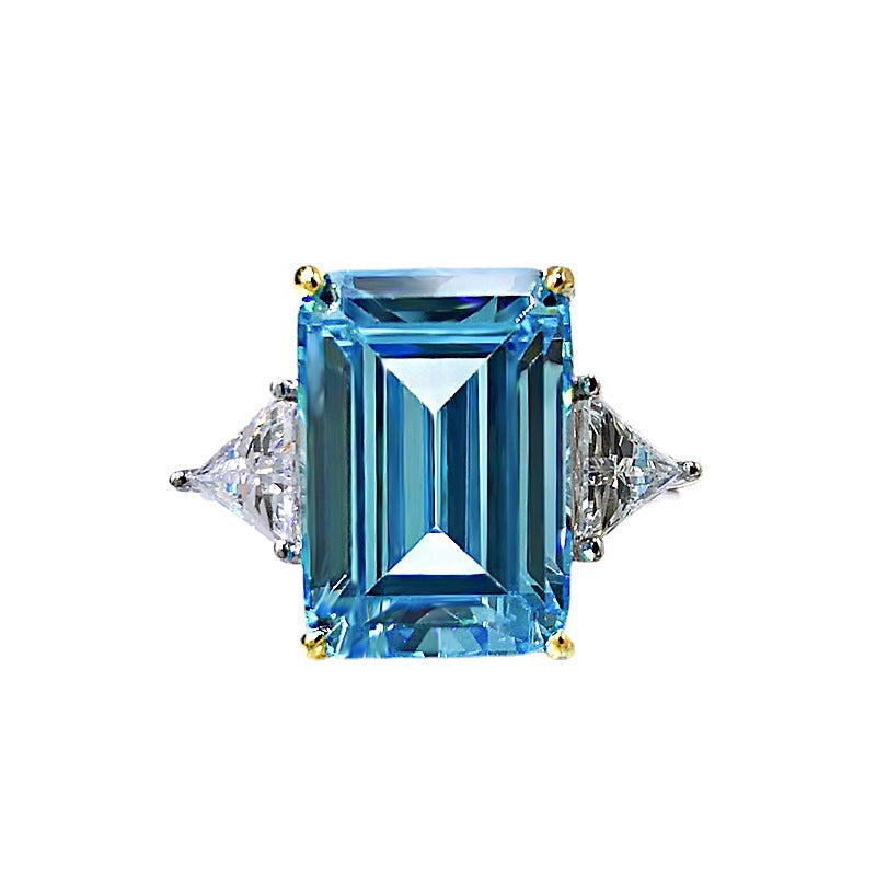 Elegant emerald cut aquamarine ring set in 925 sterling silver with white sapphire accents, showcasing a sparkling blue gemstone.