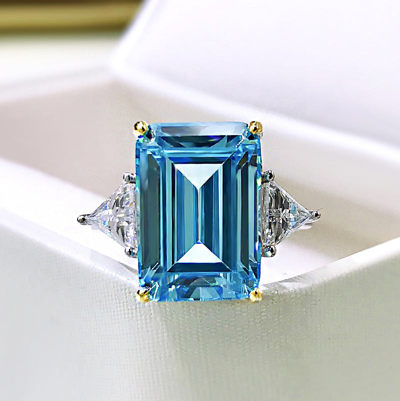 Elegant emerald cut aquamarine ring set in 925 sterling silver with white sapphire accents, showcasing a sparkling blue gemstone.