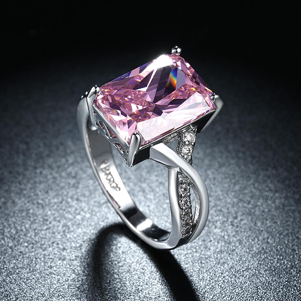 Emerald cut pink crystal swirl ring set in 18K white gold plating, showcasing a stunning design with crystal pave detailing.