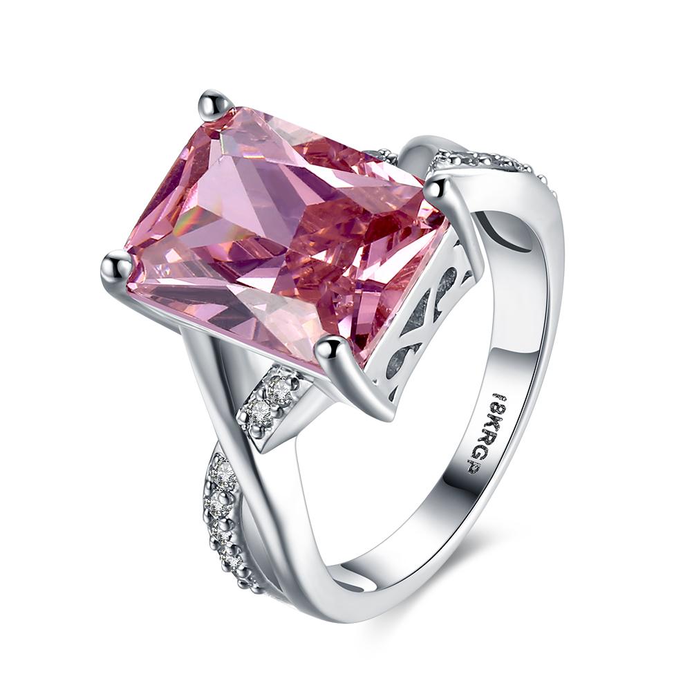 Emerald cut pink crystal swirl ring set in 18K white gold plating, showcasing a stunning design with crystal pave detailing.