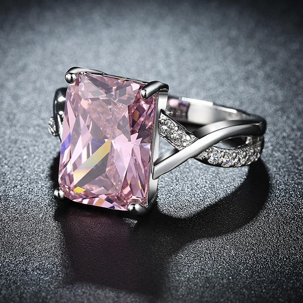 Emerald cut pink crystal swirl ring set in 18K white gold plating, showcasing a stunning design with crystal pave detailing.