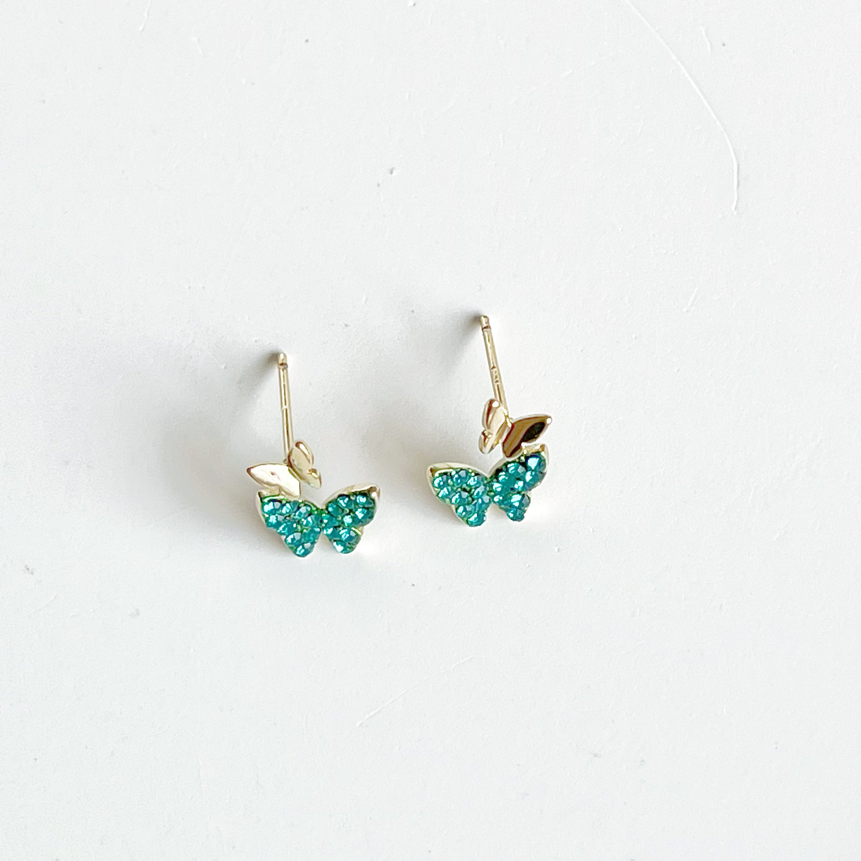 Emerald green crystal butterflies earrings made of gold-plated sterling silver and bronze, featuring sparkling green zircon stones.