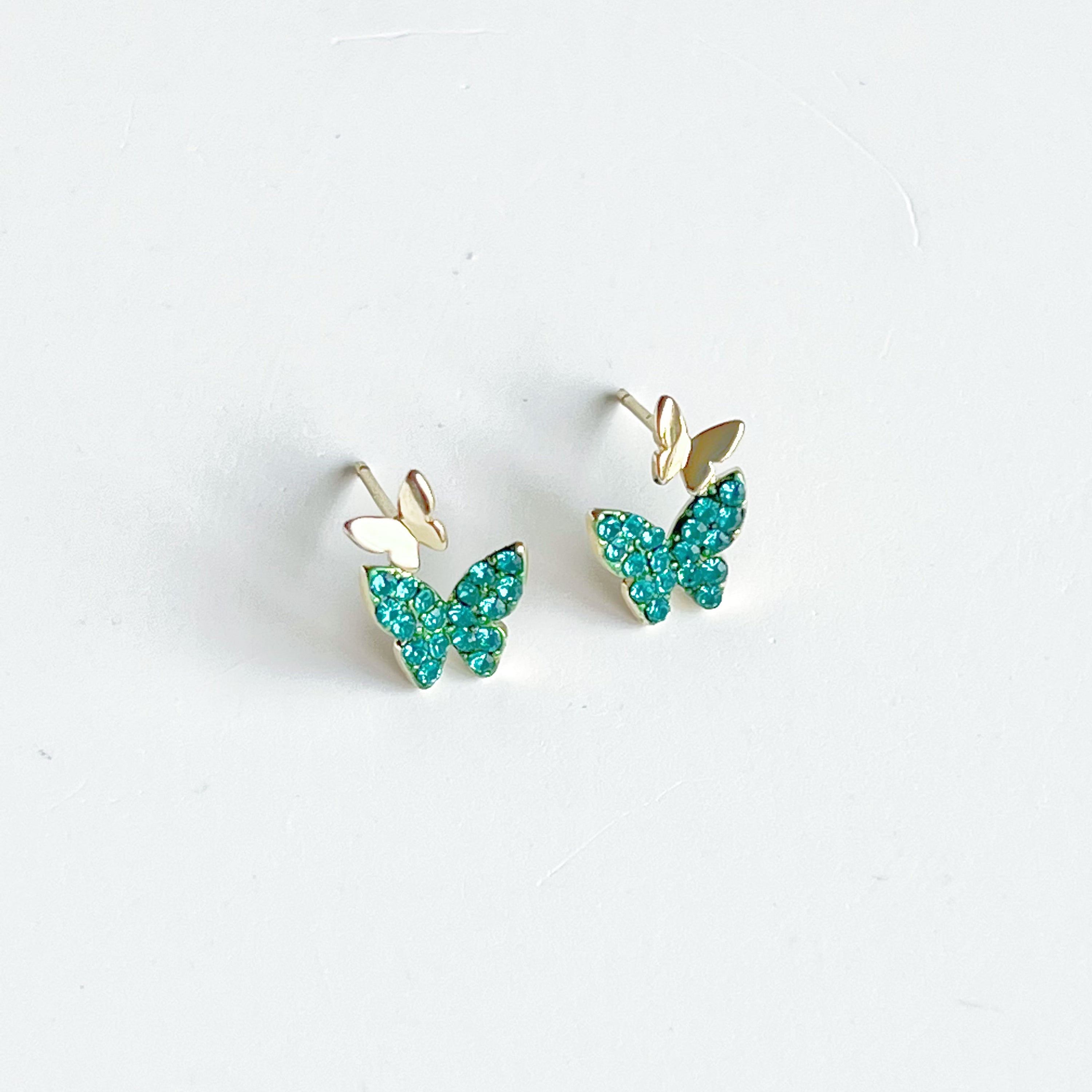 Emerald green crystal butterflies earrings made of gold-plated sterling silver and bronze, featuring sparkling green zircon stones.