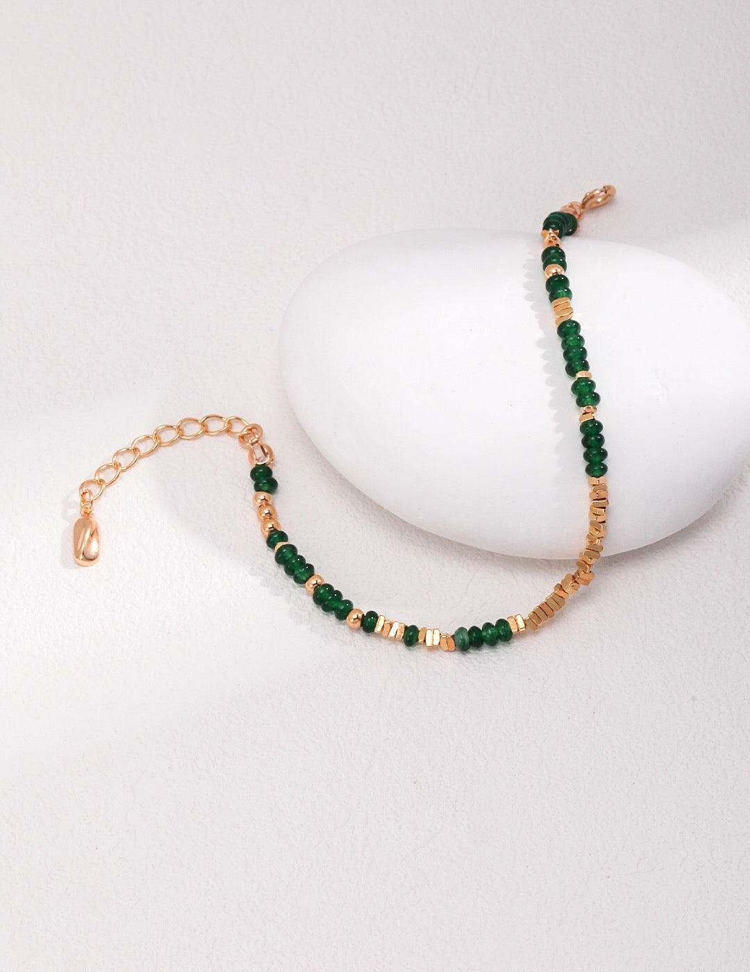 Emerald Sterling Silver Broken Bracelet featuring synthetic emeralds and gold vermeil accents, elegantly displayed on a soft fabric background.