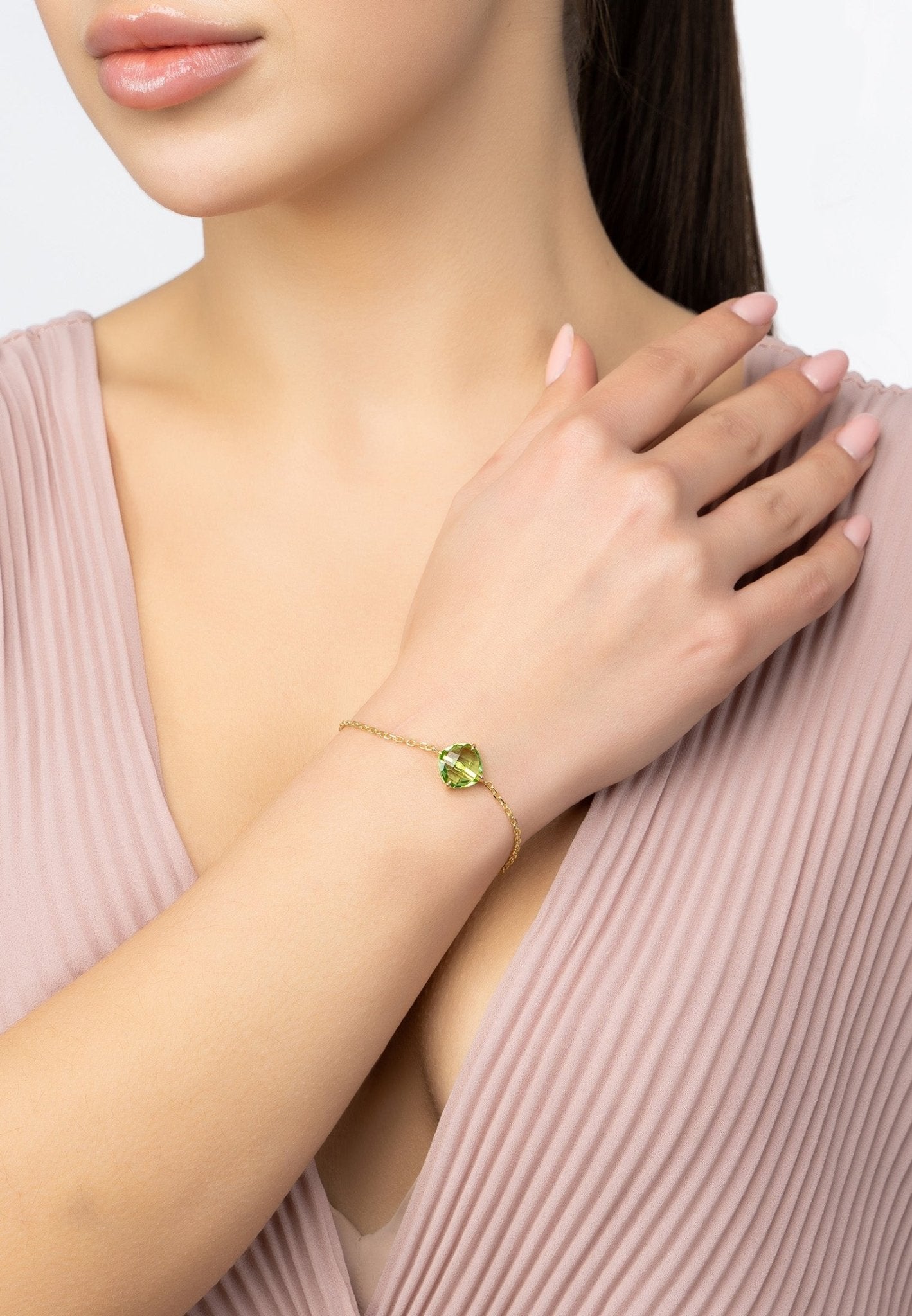 Empress Peridot Gemstone Bracelet in gold with a vibrant green peridot gemstone, elegantly displayed on a soft surface.