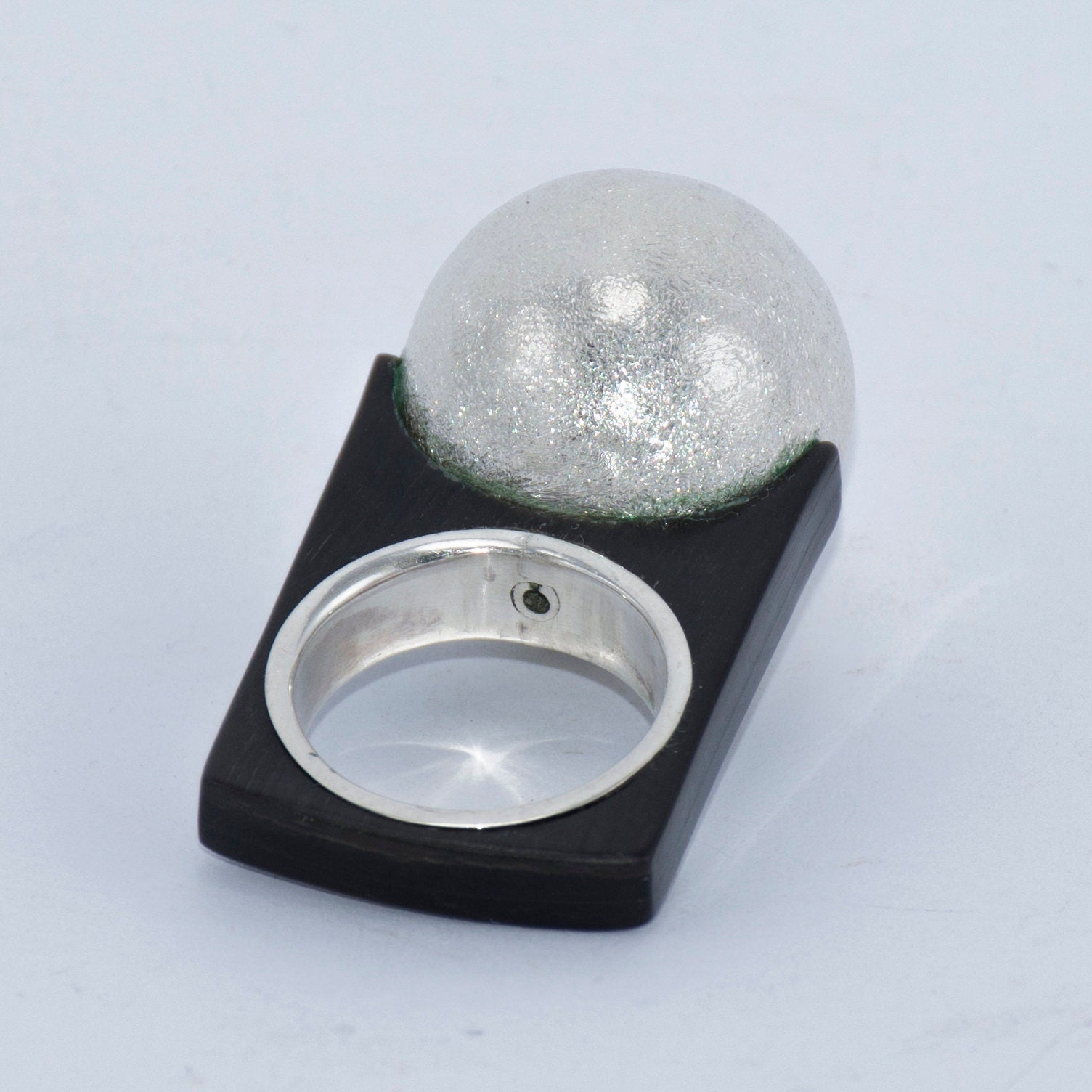 A unique engagement ring made from buffalo horn with a silver ball accent, showcasing its handcrafted design.