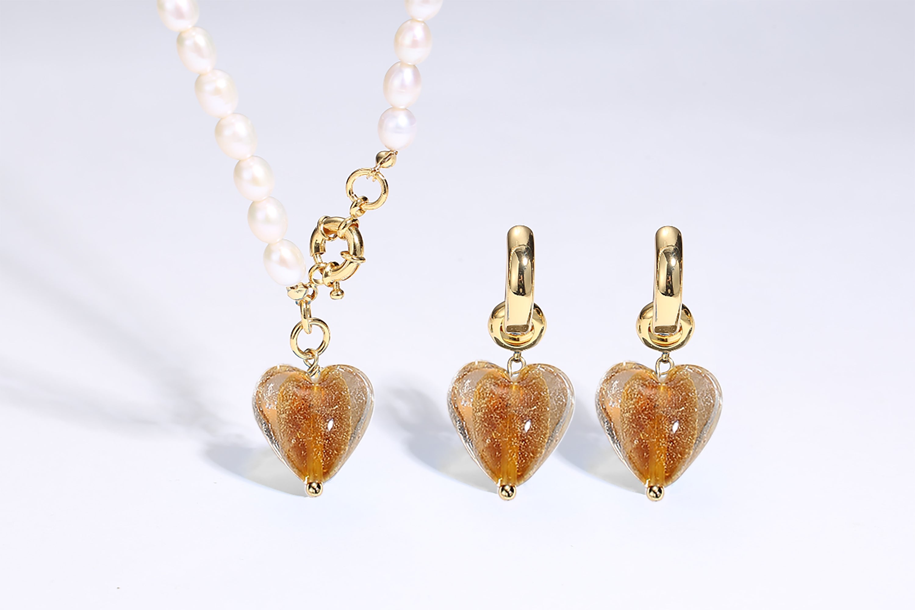 Esmée Amber Glaze Heart Dangle Earrings featuring colorful glass hearts and 18k gold plated hoops, showcasing unique handmade craftsmanship.