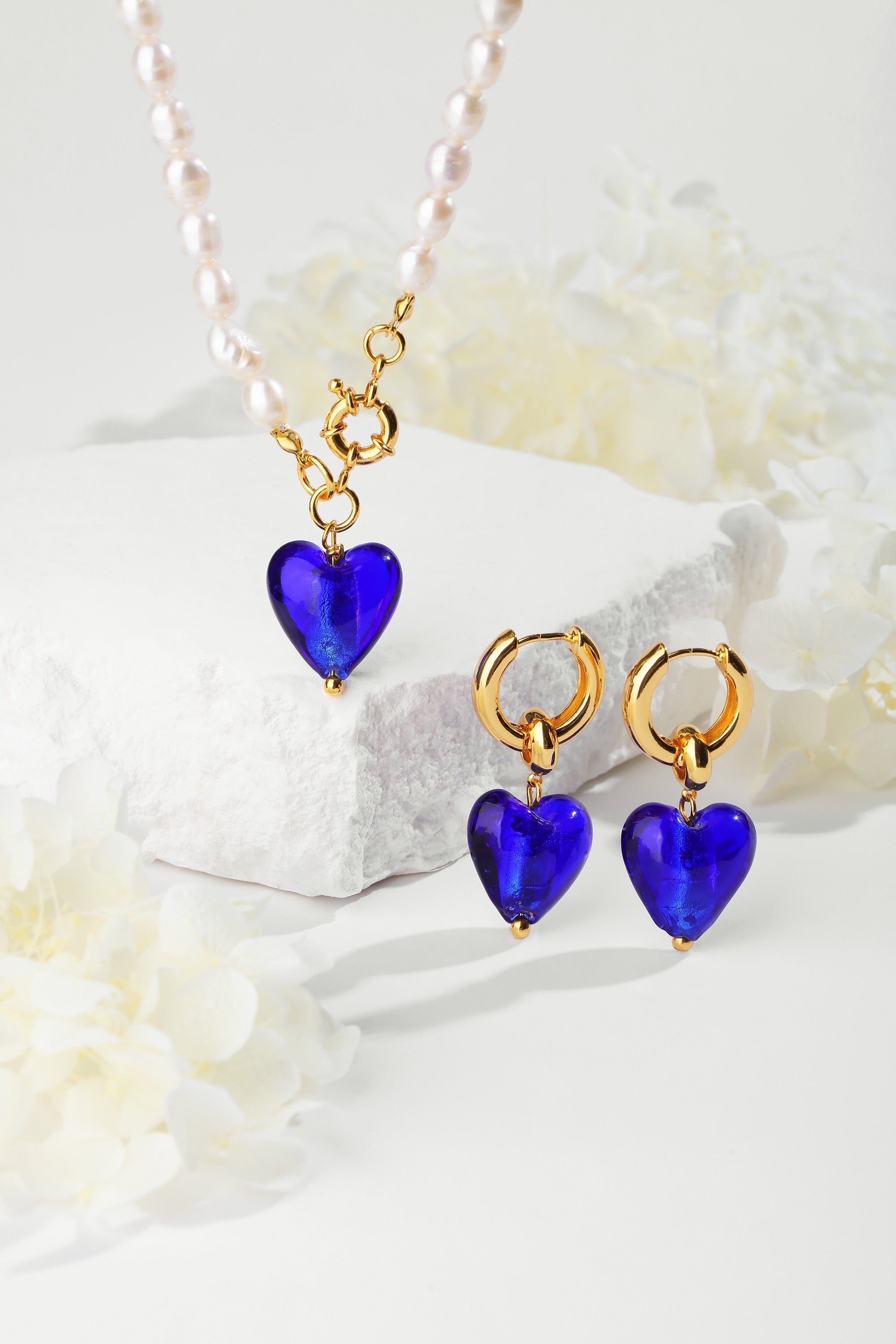 Esmée Blue Glaze Heart Dangle Earrings featuring colorful glass hearts and 18k gold plated hoops, showcasing unique handmade craftsmanship.