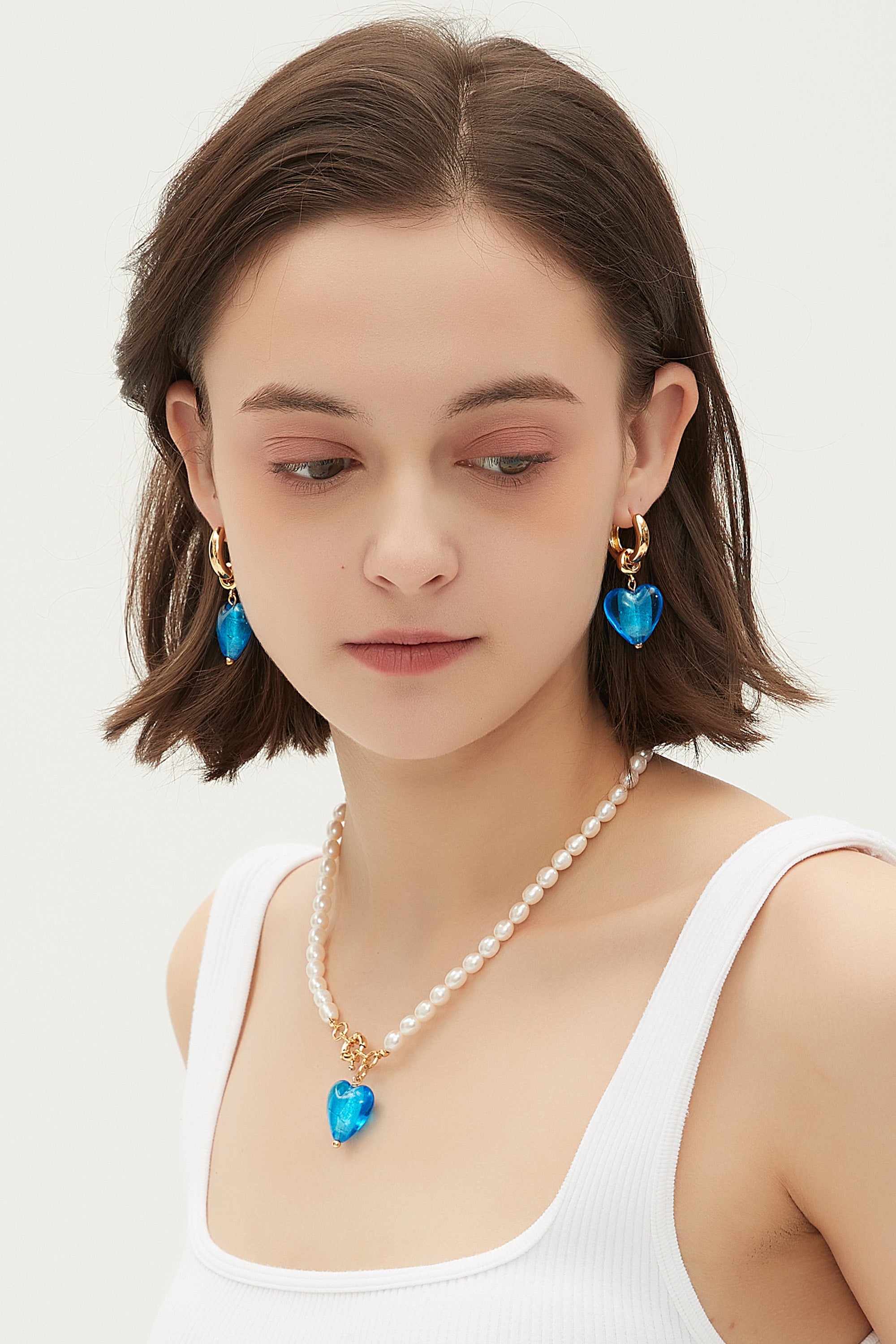 Esmée Sky Blue Glaze Heart Dangle Earrings featuring colorful handmade glass hearts and 18k gold plated hoops.