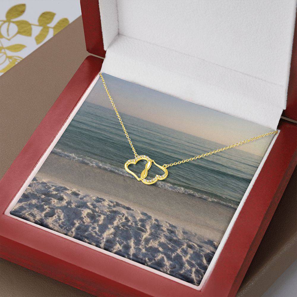 Everlasting Gold Heart Necklace featuring two interconnected hearts in 10K solid yellow gold with 18 pave set diamonds, displayed in a luxurious mahogany gift box.