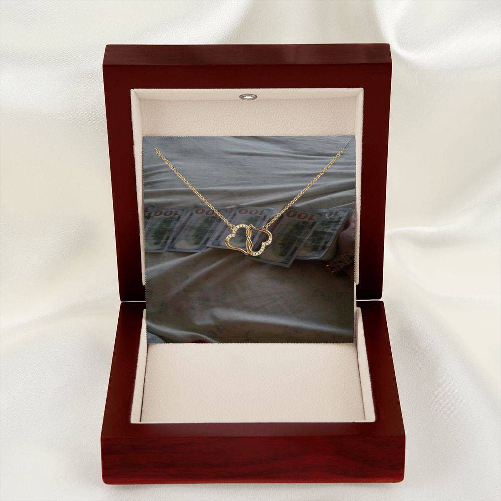 A beautiful Everlasting Love necklace featuring two connected 10K gold hearts adorned with 18 sparkling diamonds, presented in a luxurious mahogany gift box.