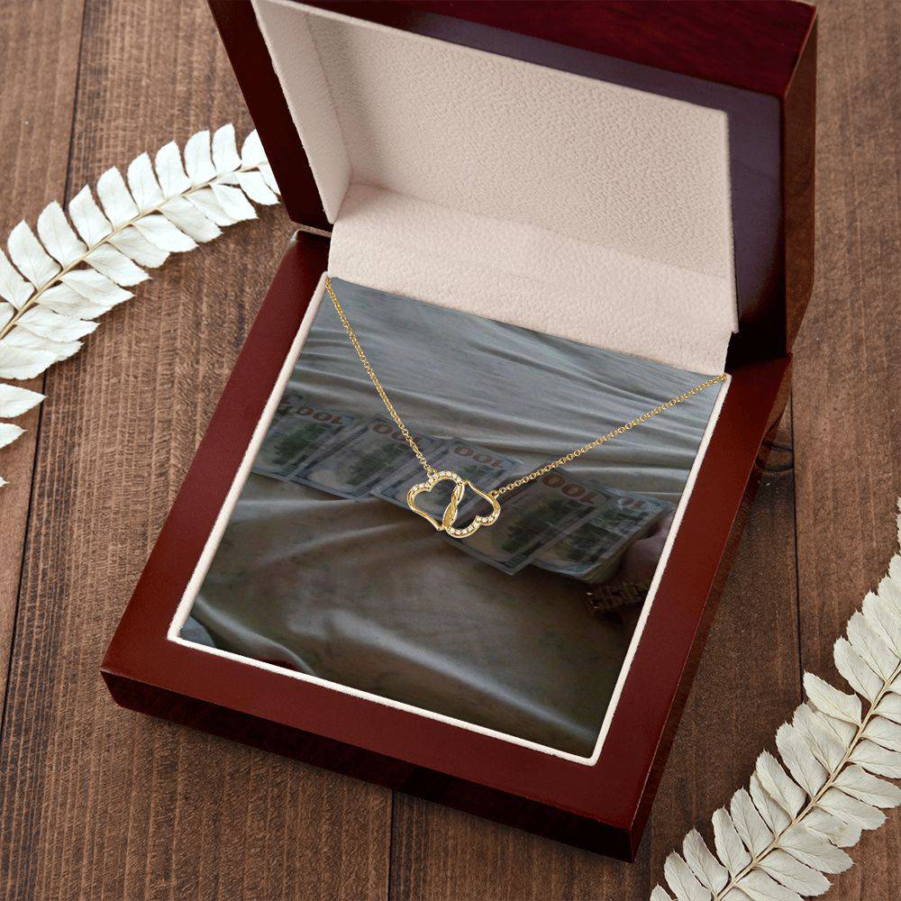 A beautiful Everlasting Love necklace featuring two connected 10K gold hearts adorned with 18 sparkling diamonds, presented in a luxurious mahogany gift box.