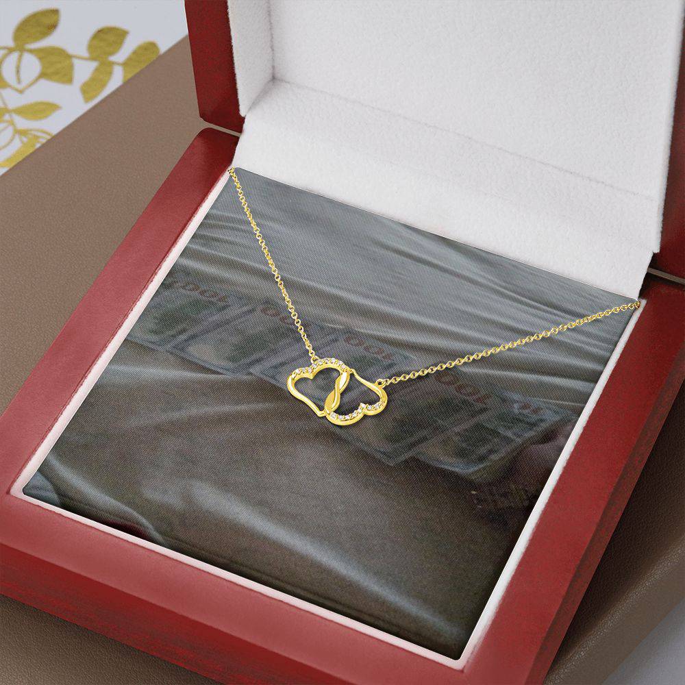 A beautiful Everlasting Love necklace featuring two connected 10K gold hearts adorned with 18 sparkling diamonds, presented in a luxurious mahogany gift box.