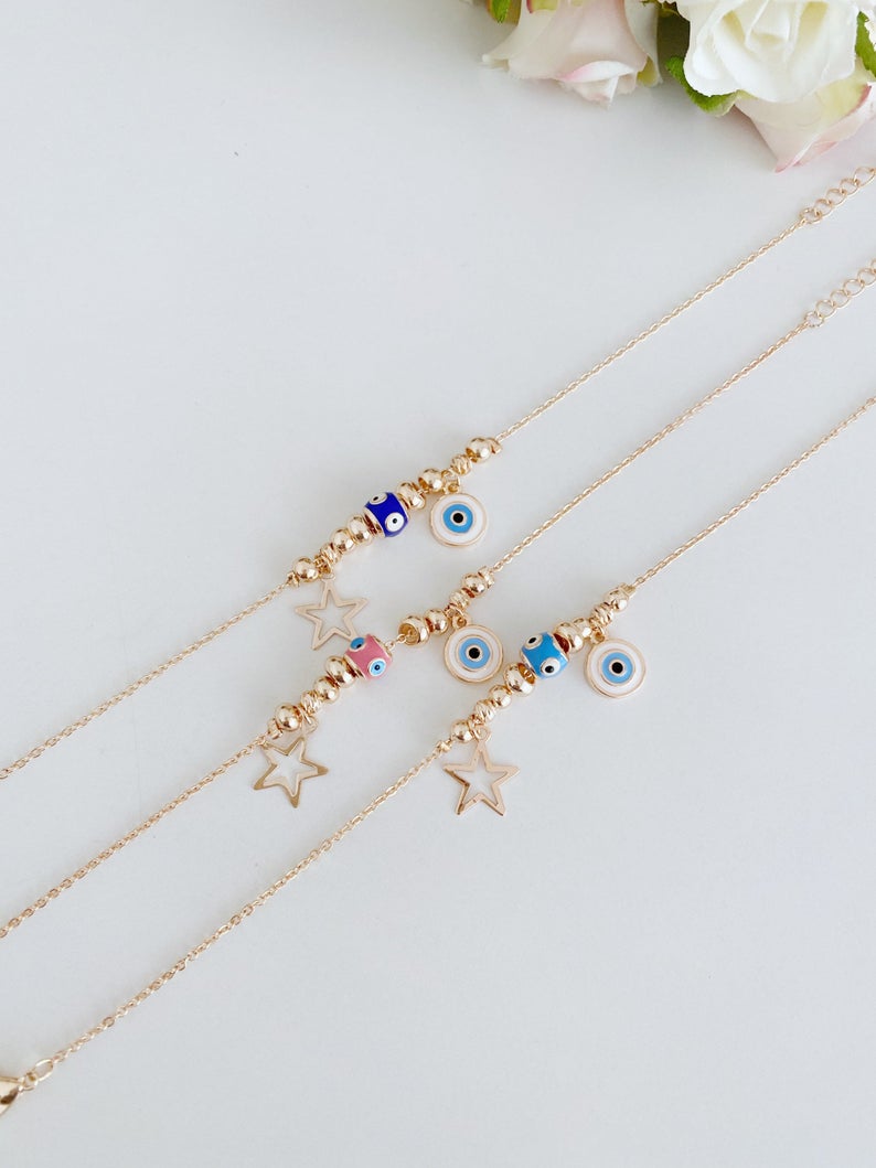 Rose gold evil eye anklet featuring a protective charm and star, perfect for beachwear.