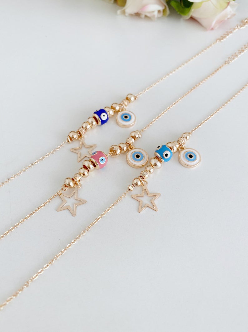 Rose gold evil eye anklet featuring a protective charm and star, perfect for beachwear.