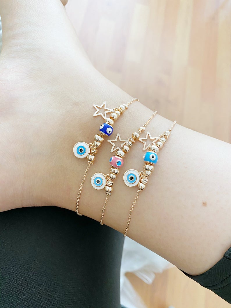 Rose gold evil eye anklet featuring a protective charm and star, perfect for beachwear.