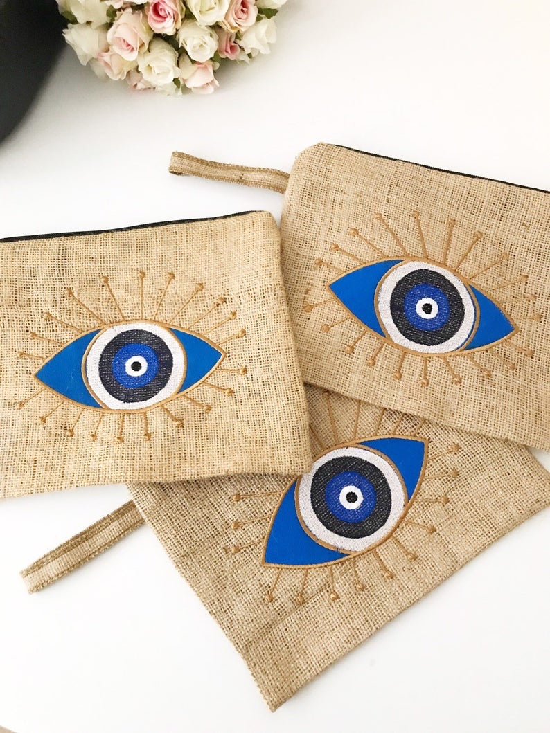 Handmade evil eye bag made from high-quality jute, featuring a blue evil eye design, perfect for beach outings and special occasions.