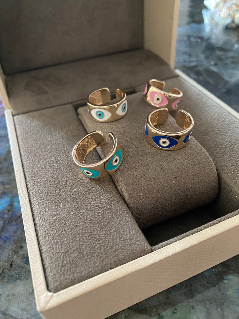 Gold wide adjustable Evil Eye Band Ring featuring colorful eye charms, symbolizing protection and style.