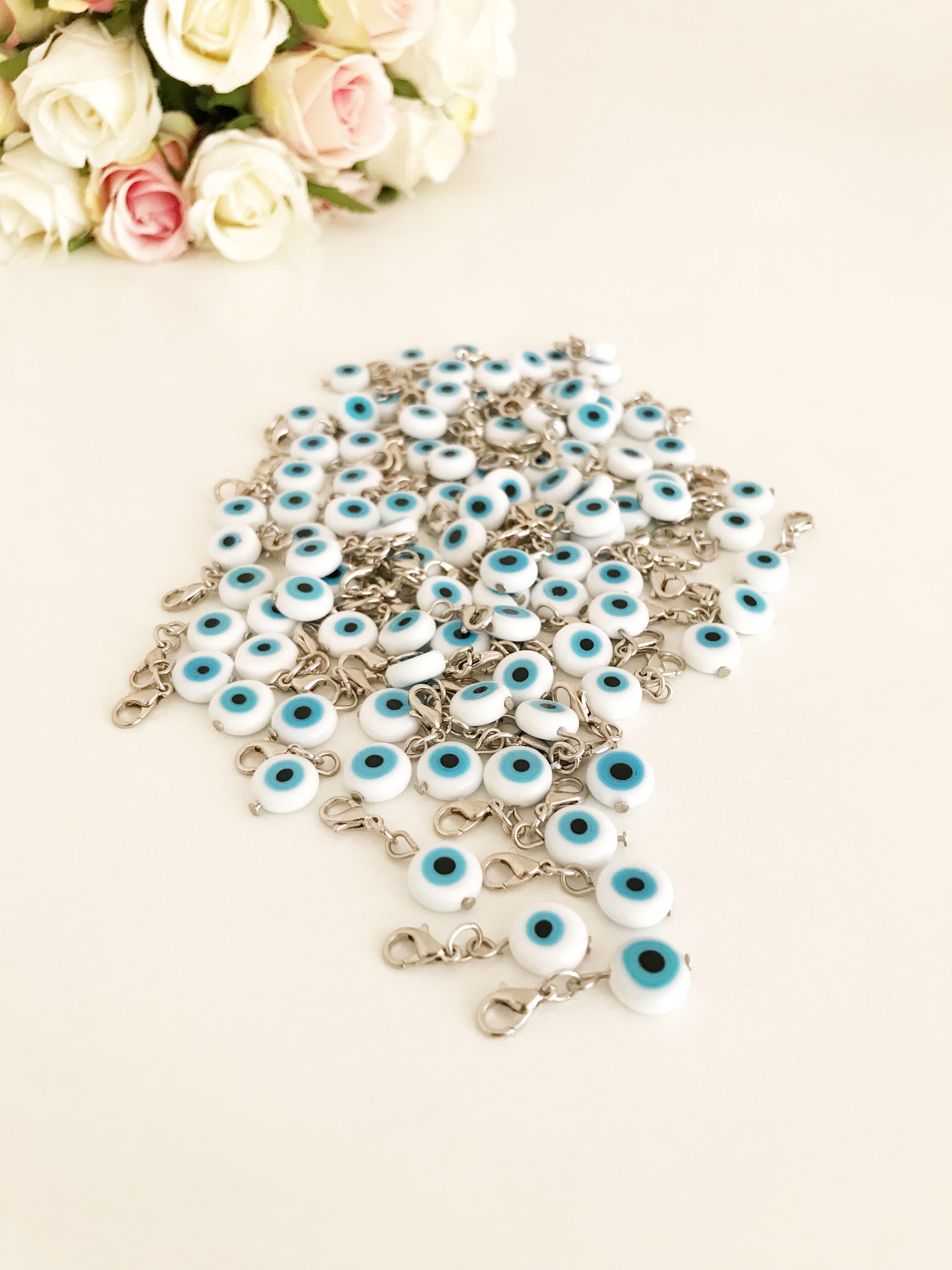 Evil Eye Bead with lobster clasp featuring a white evil eye charm and transparent blue beads, ideal for keychains and jewelry.