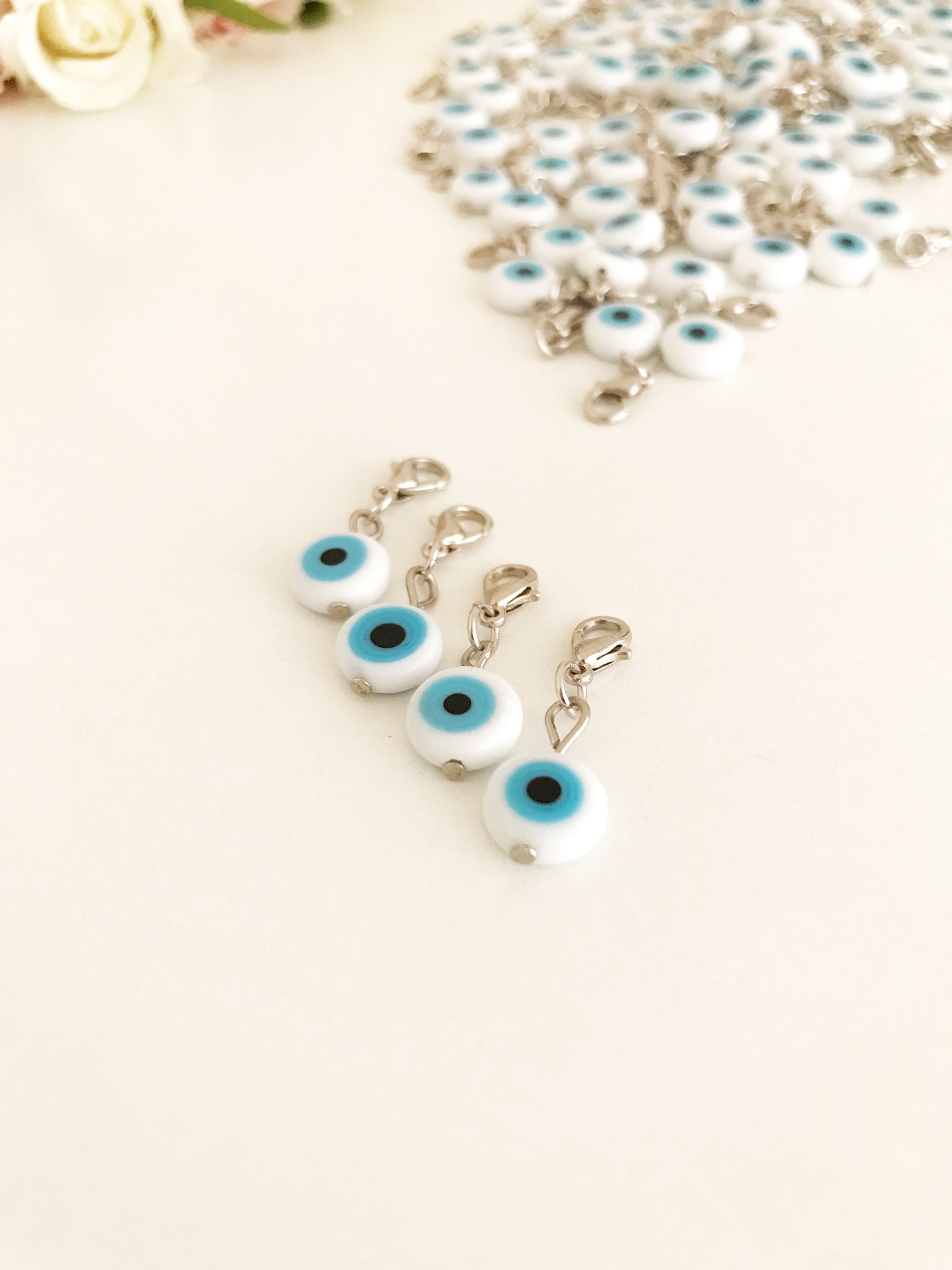 Evil Eye Bead with lobster clasp featuring a white evil eye charm and transparent blue beads, ideal for keychains and jewelry.