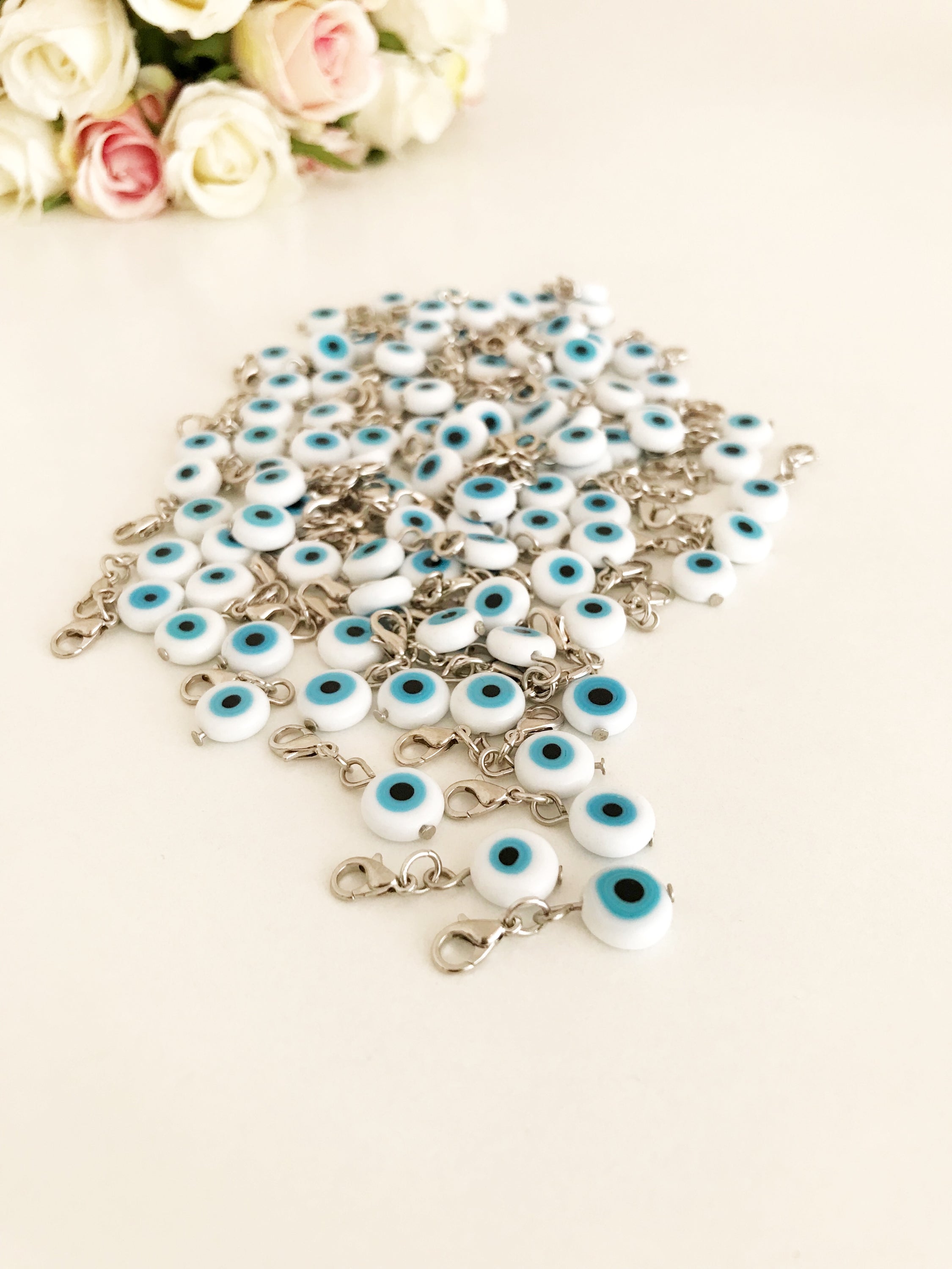 Evil Eye Bead with lobster clasp featuring a white evil eye charm and transparent blue beads, ideal for keychains and jewelry.