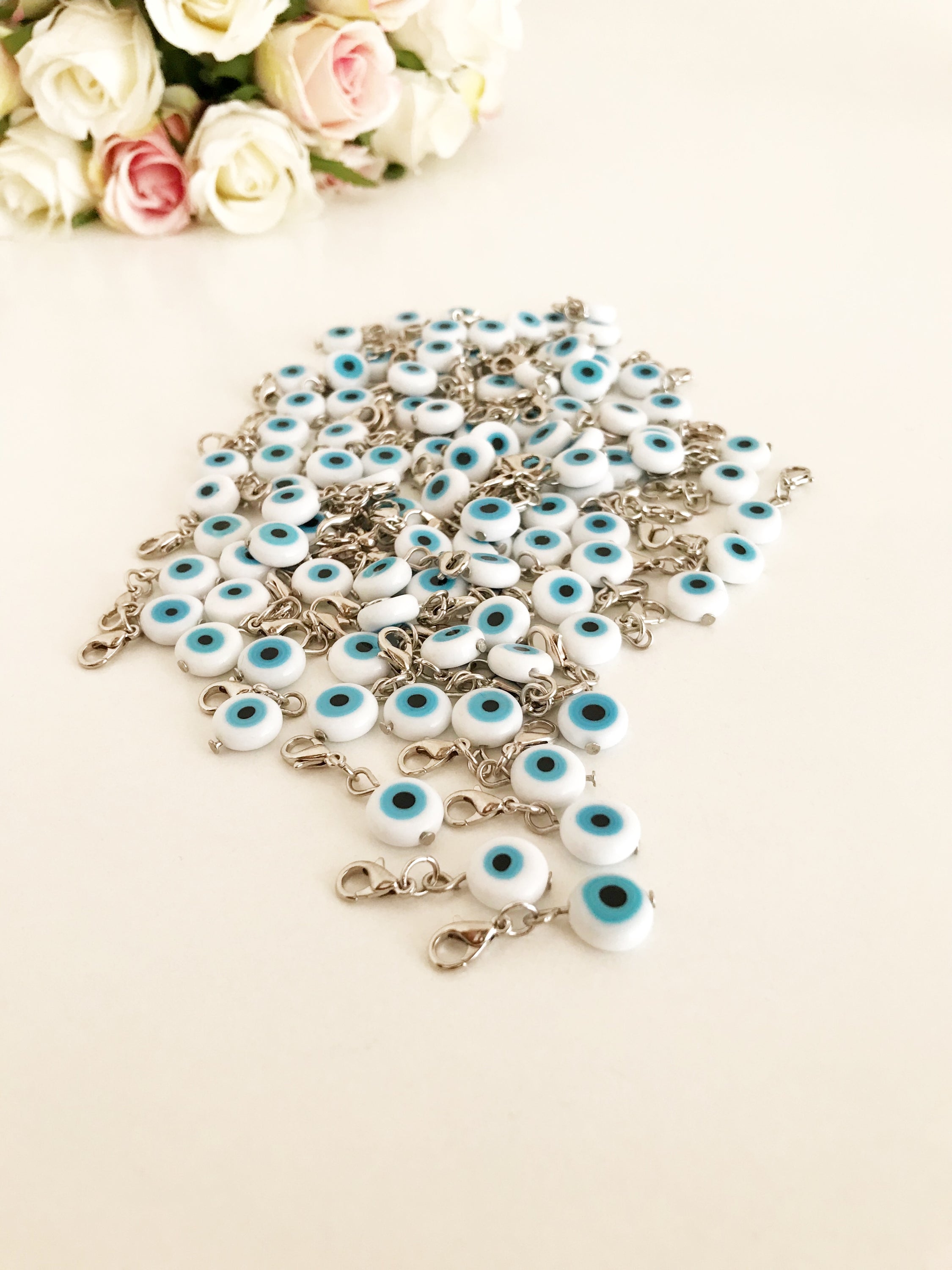 Evil Eye Bead with lobster clasp featuring a white evil eye charm and transparent blue beads, ideal for keychains and jewelry.