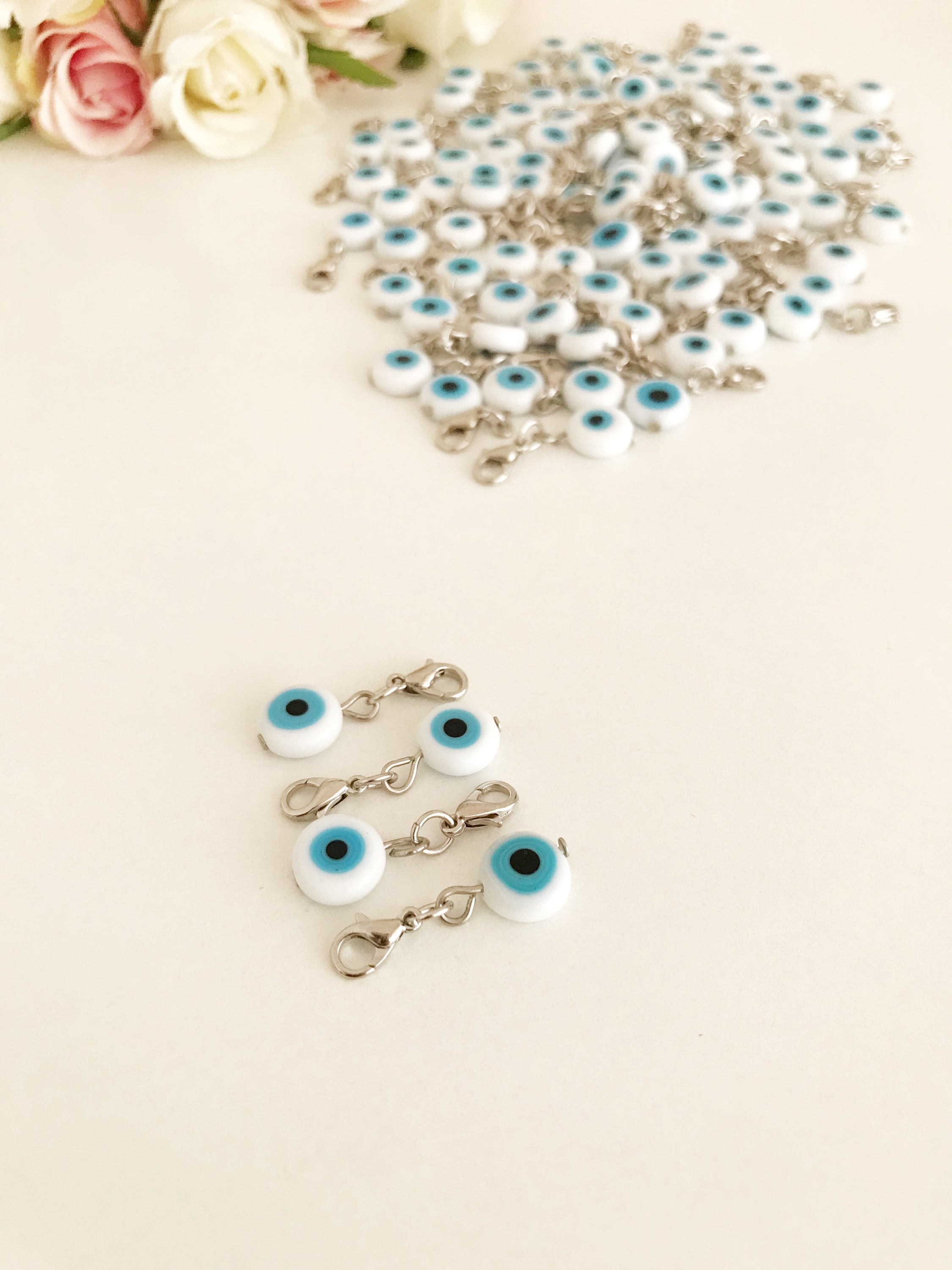 Evil Eye Bead with lobster clasp featuring a white evil eye charm and transparent blue beads, ideal for keychains and jewelry.