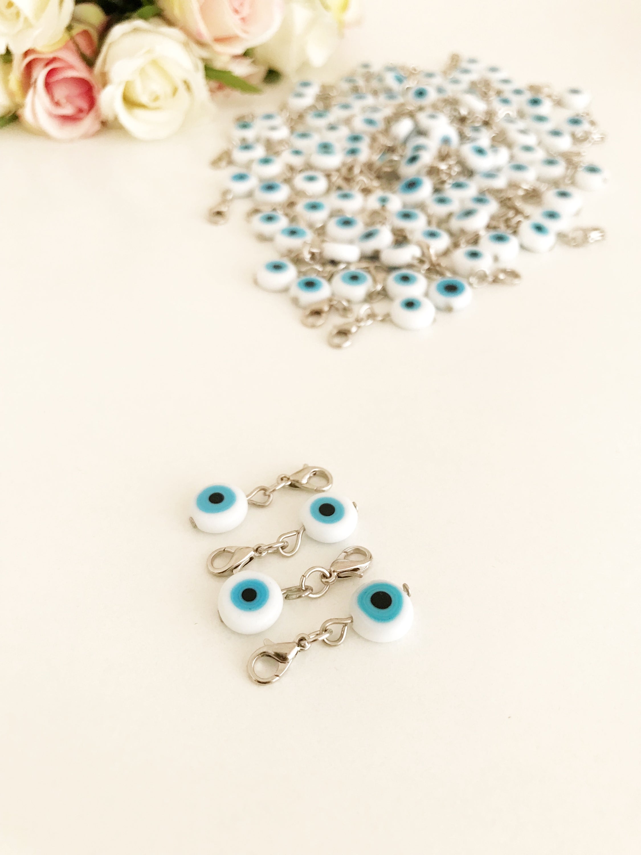 Evil Eye Bead with lobster clasp featuring a white evil eye charm and transparent blue beads, ideal for keychains and jewelry.