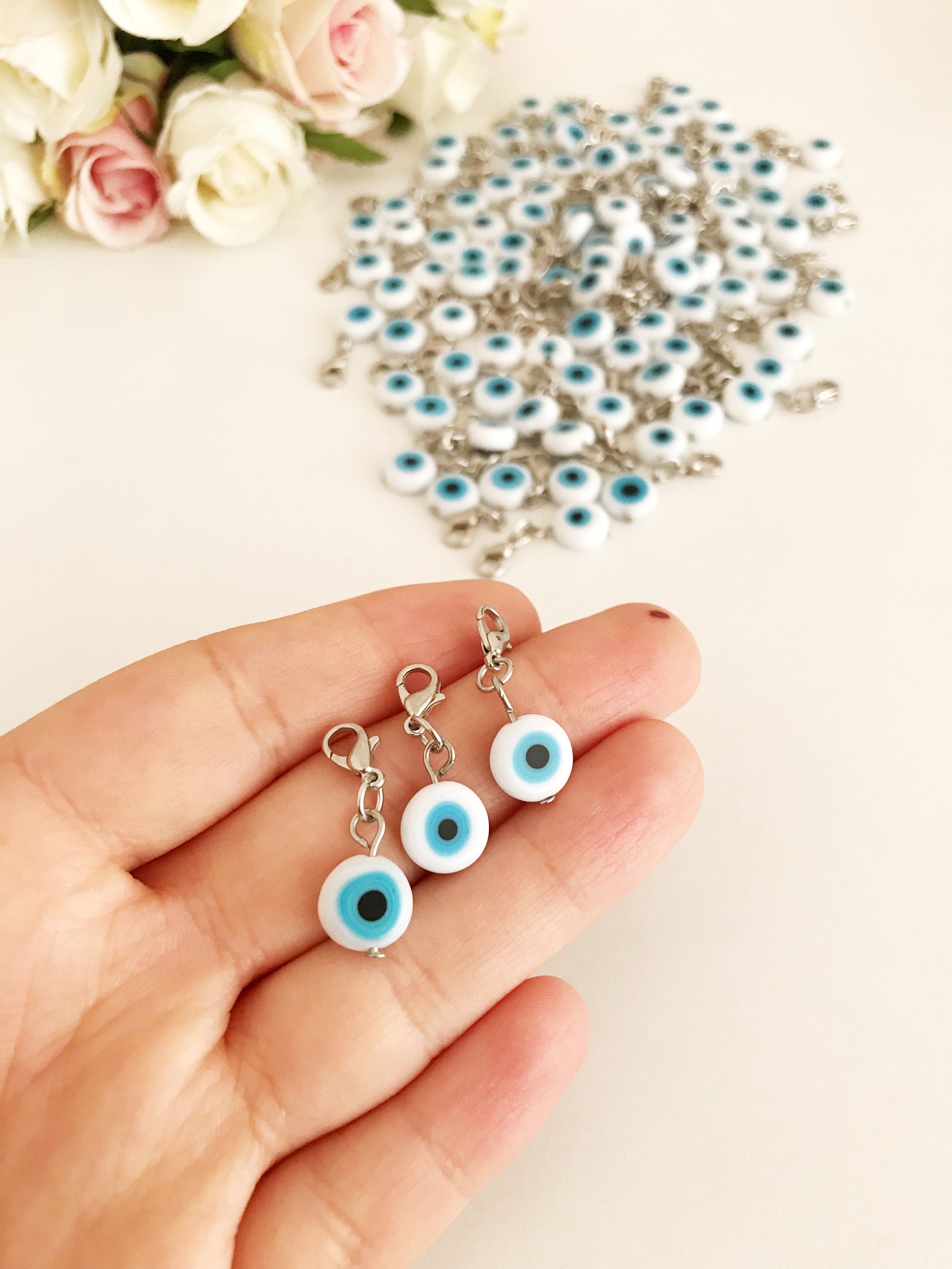 Evil Eye Bead with lobster clasp featuring a white evil eye charm and transparent blue beads, ideal for keychains and jewelry.