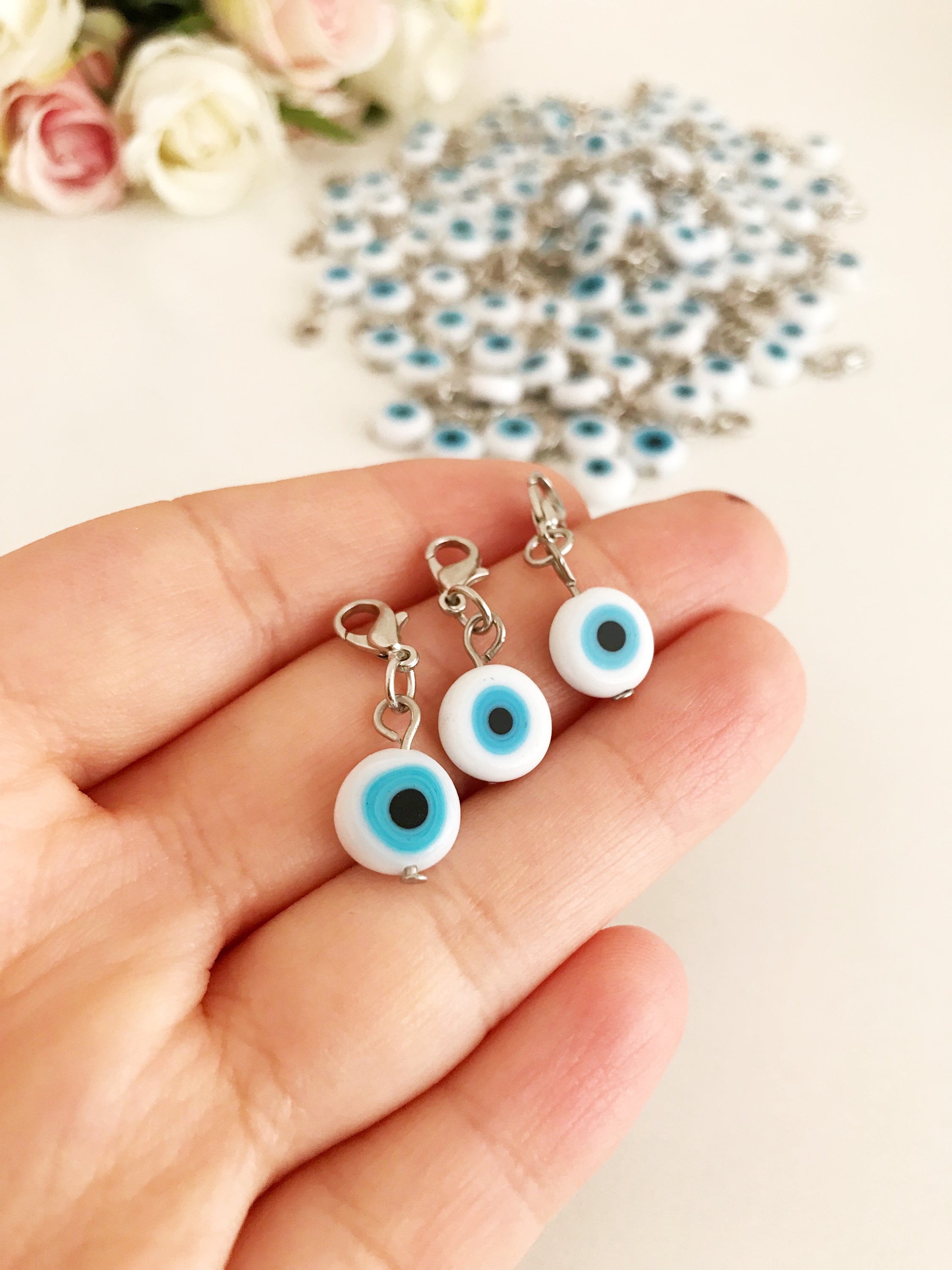 Evil Eye Bead with lobster clasp featuring a white evil eye charm and transparent blue beads, ideal for keychains and jewelry.