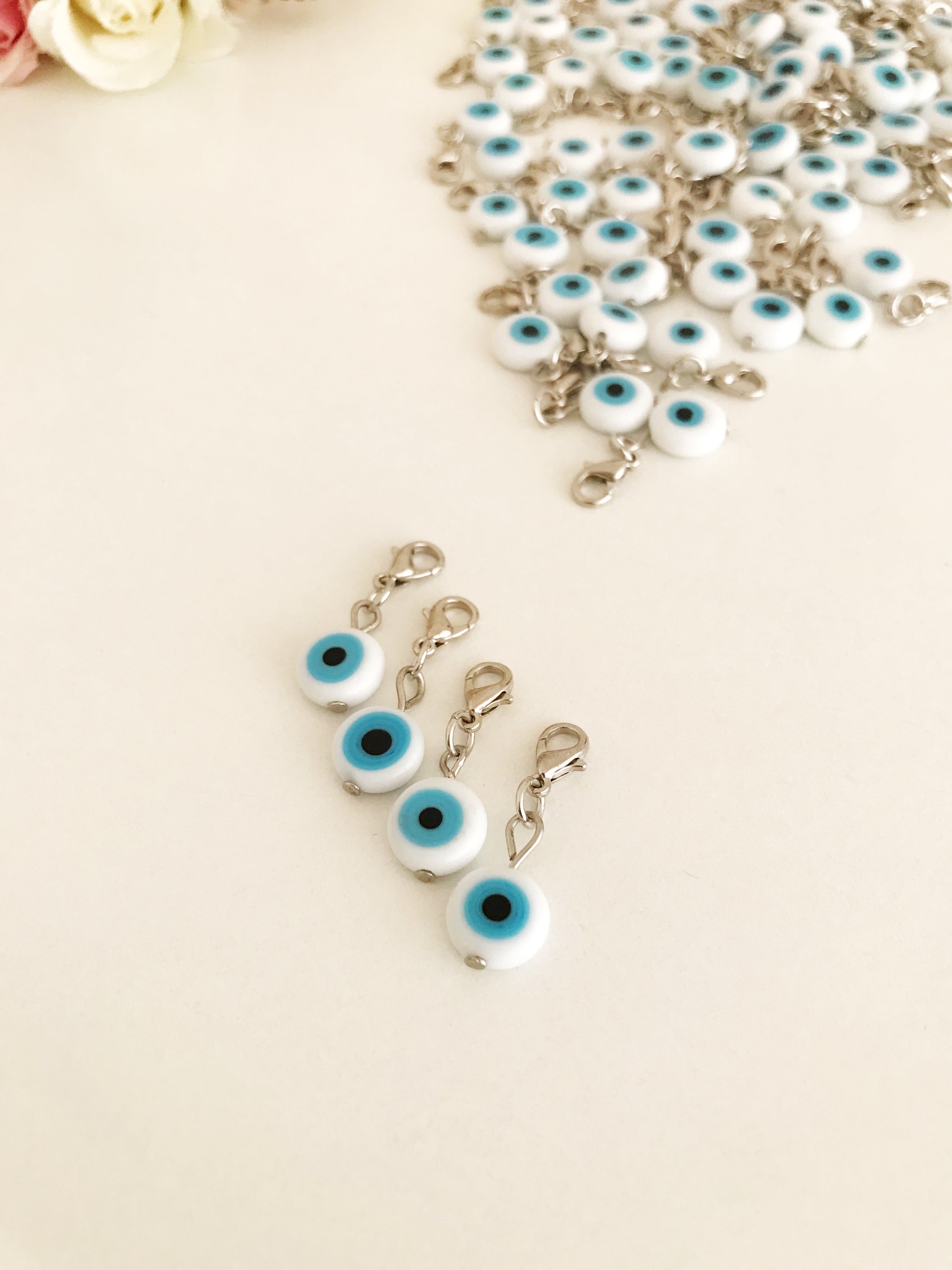 Evil Eye Bead with lobster clasp featuring a white evil eye charm and transparent blue beads, ideal for keychains and jewelry.