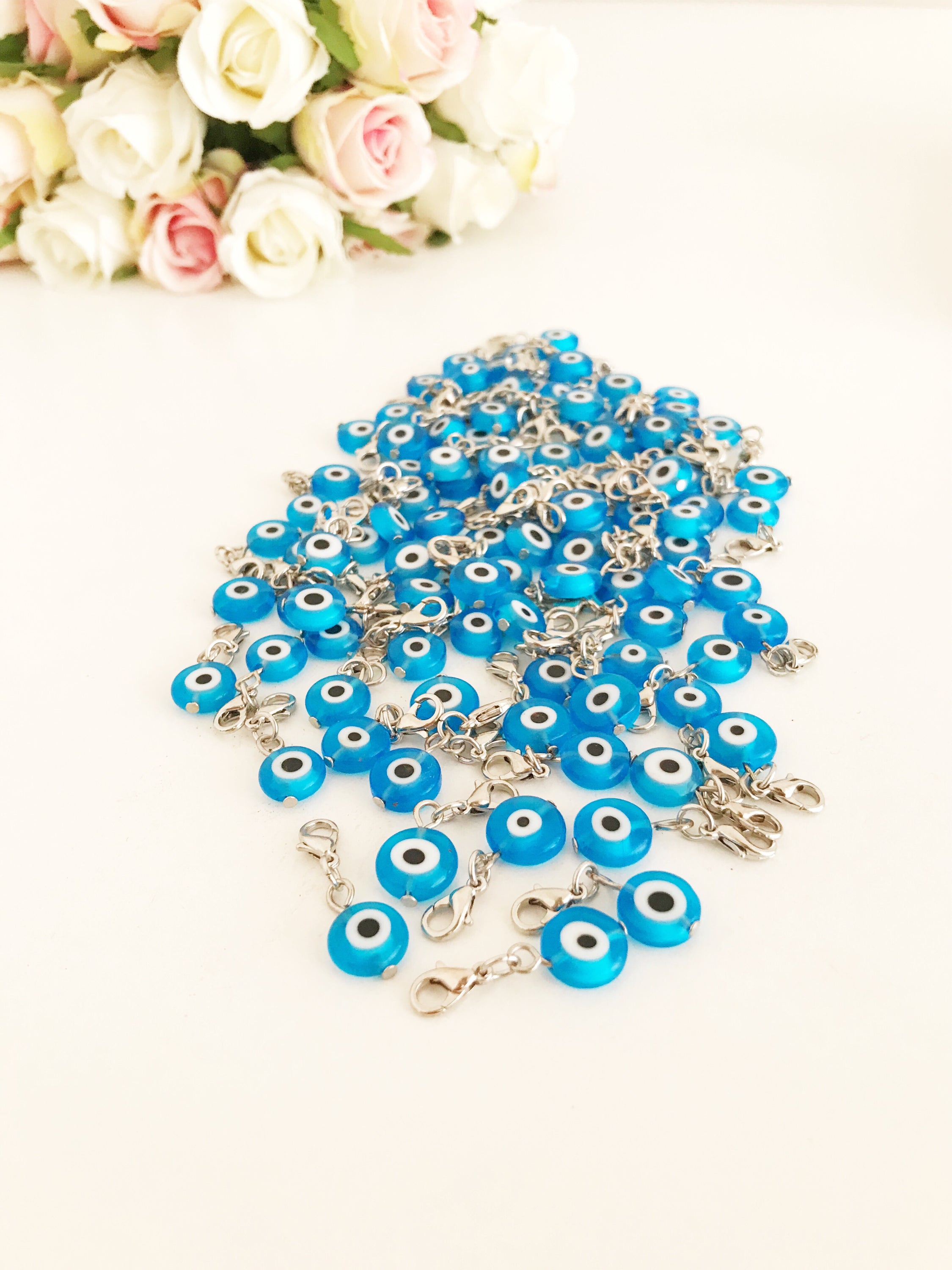 A beautiful blue evil eye bead with a lobster clasp, showcasing its transparent glass design and both-sided charm.