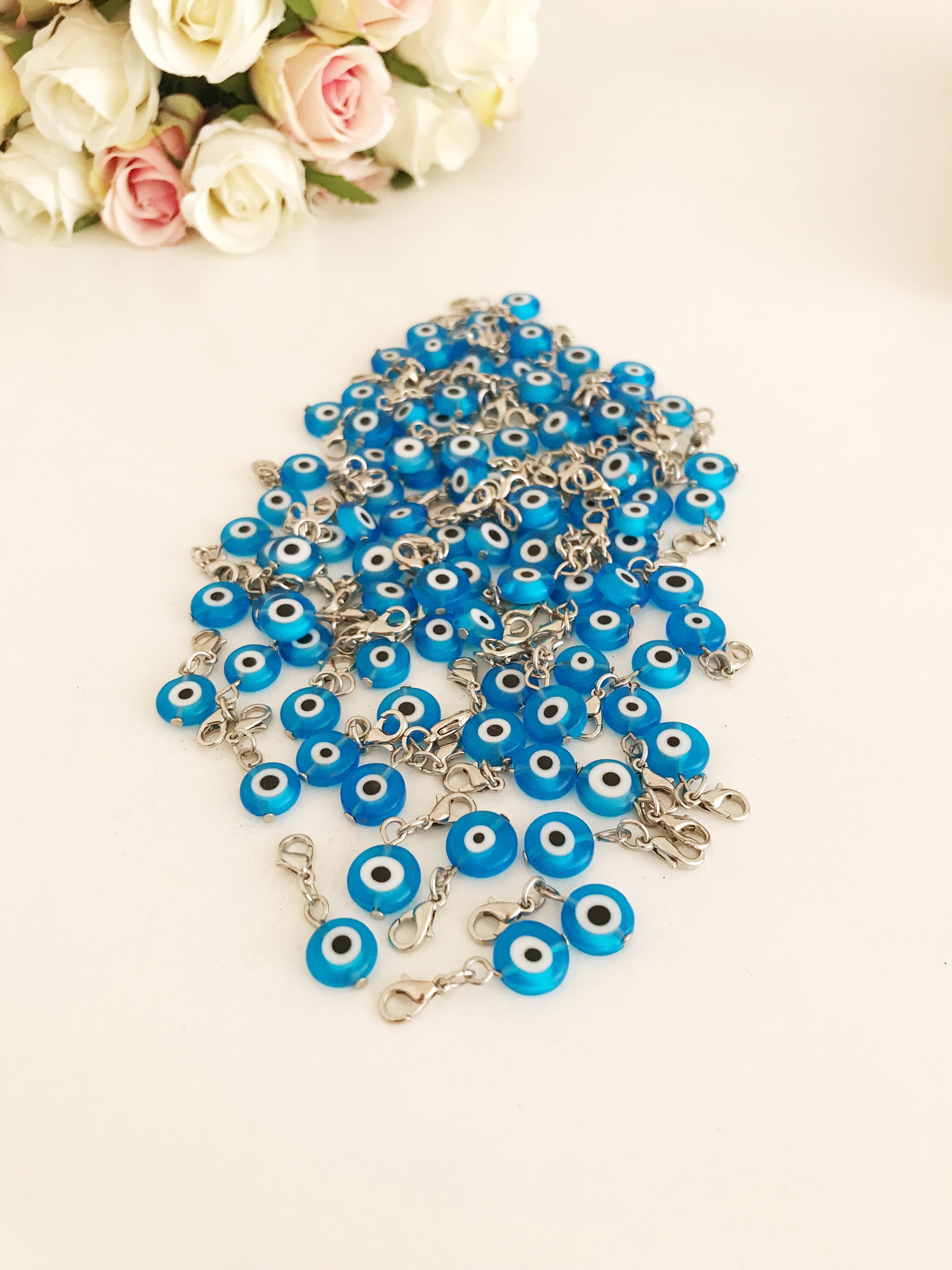 A beautiful blue evil eye bead with a lobster clasp, showcasing its transparent glass design and both-sided charm.