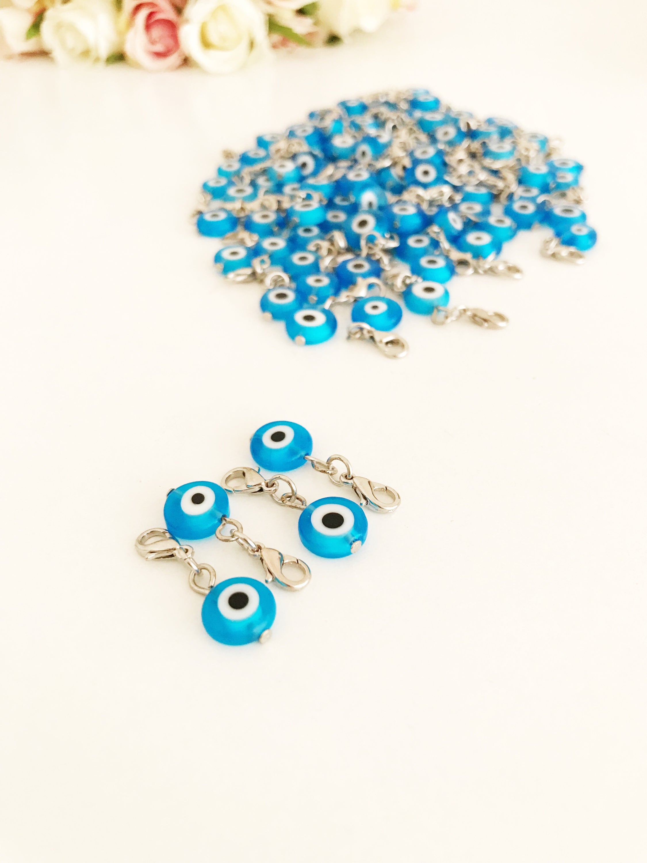 A beautiful blue evil eye bead with a lobster clasp, showcasing its transparent glass design and both-sided charm.