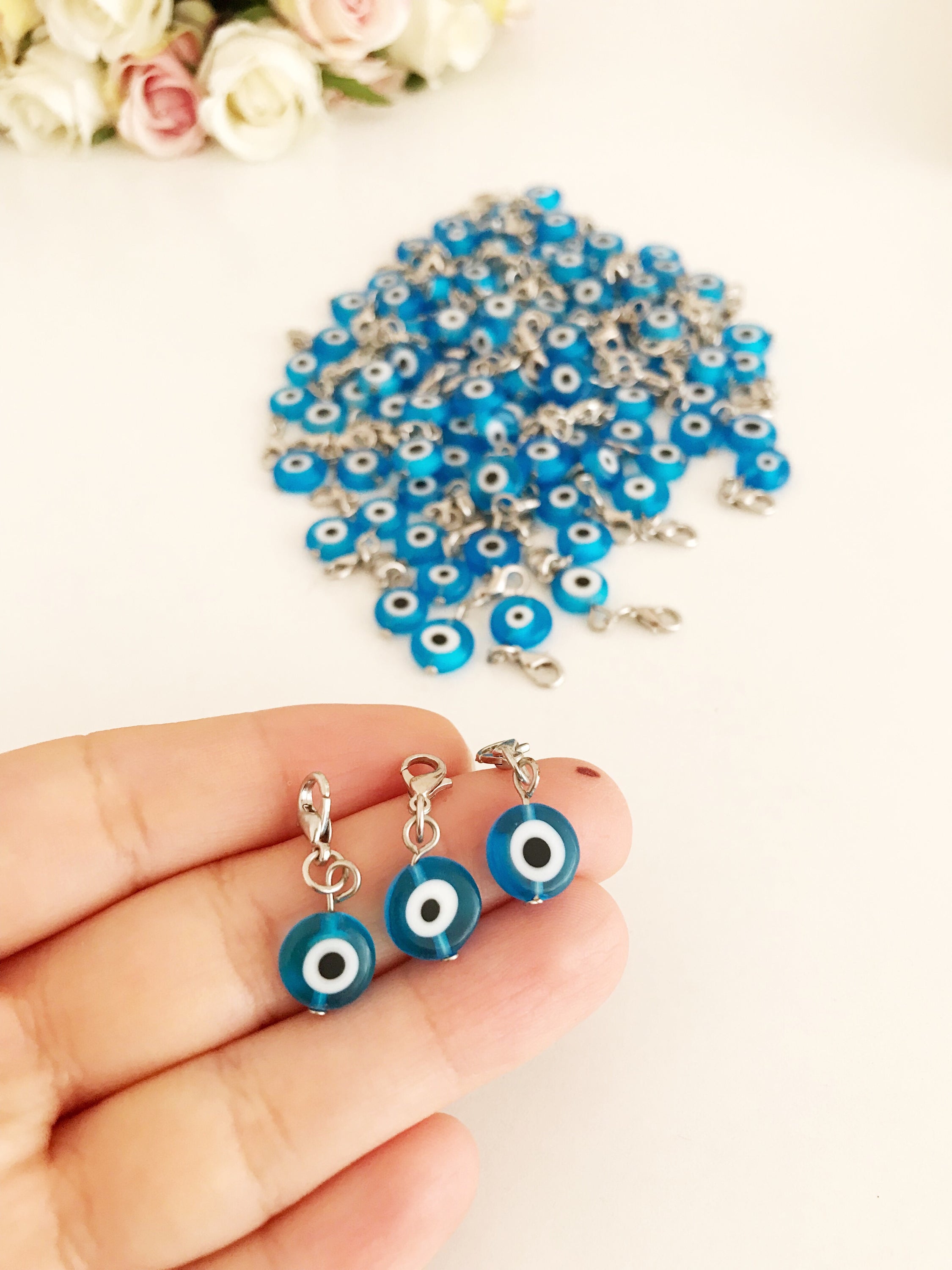 A beautiful blue evil eye bead with a lobster clasp, showcasing its transparent glass design and both-sided charm.