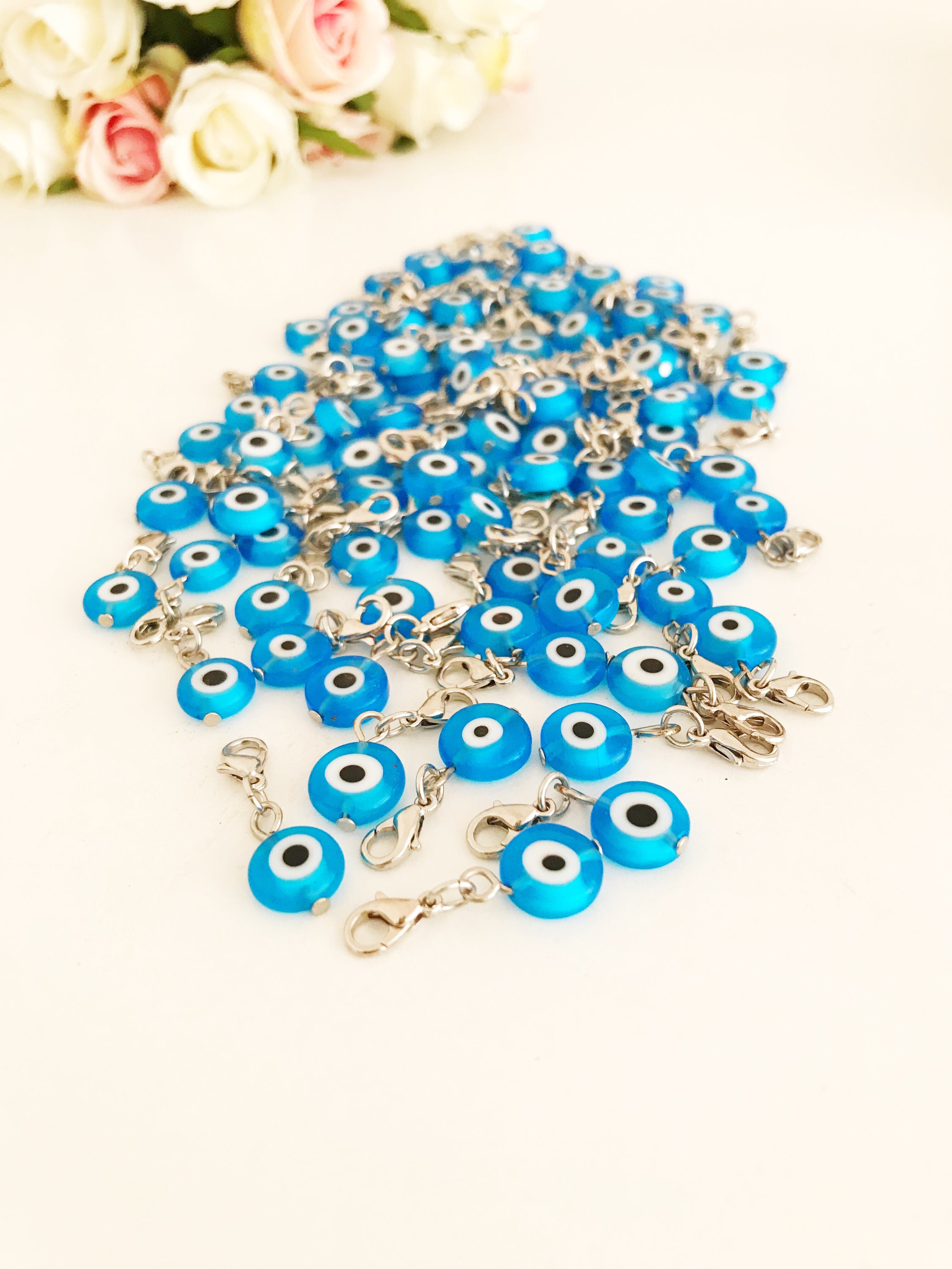 A beautiful blue evil eye bead with a lobster clasp, showcasing its transparent glass design and both-sided charm.