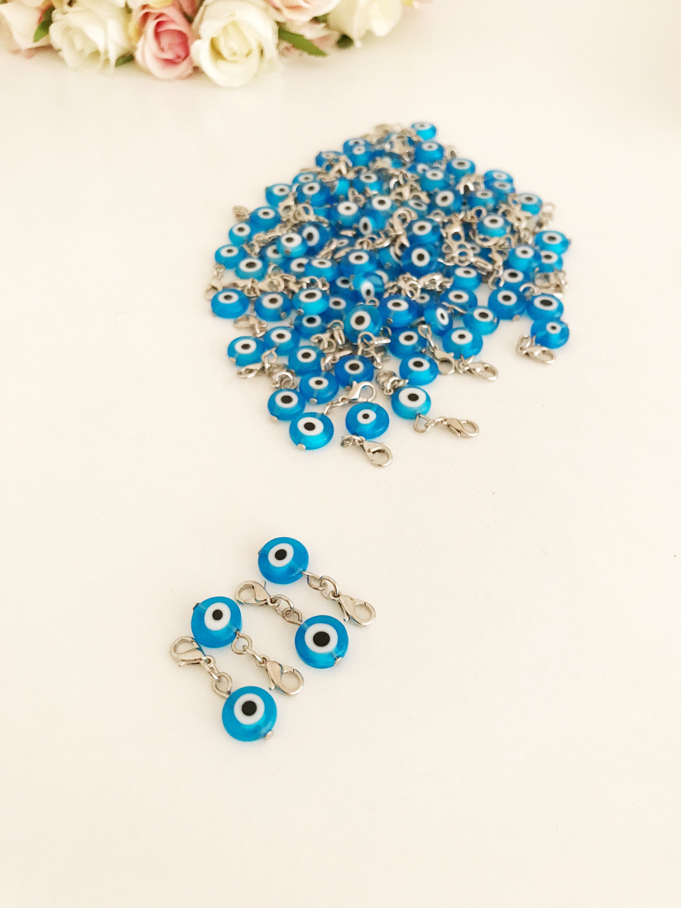 A beautiful blue evil eye bead with a lobster clasp, showcasing its transparent glass design and both-sided charm.