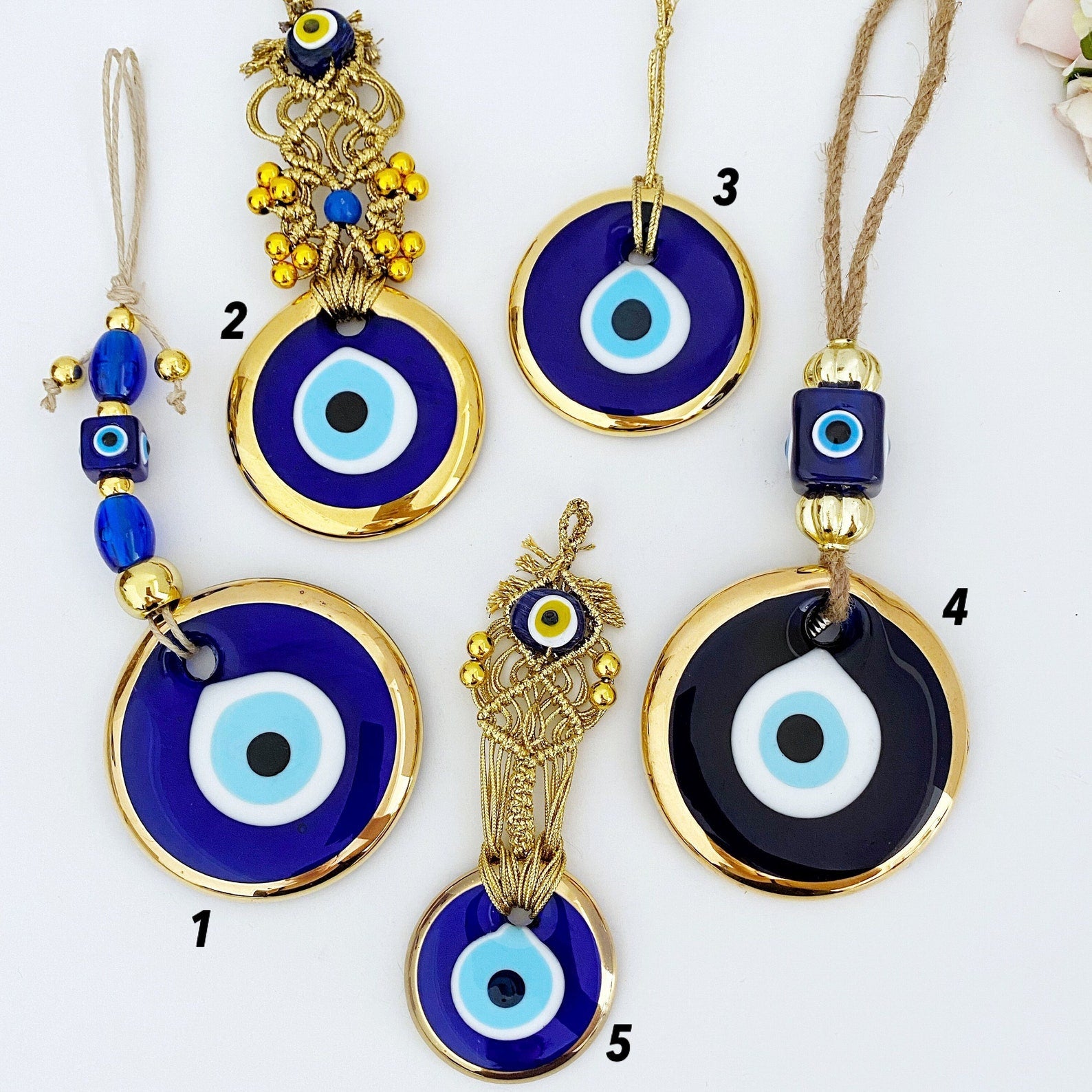 A collection of Gold Evil Eye Beads featuring various styles, showcasing their unique designs and craftsmanship, perfect for Christmas decorations.