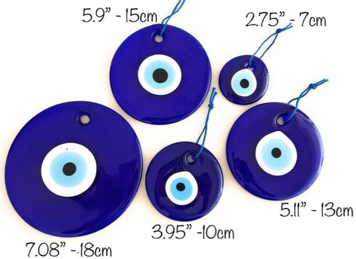 A collection of blue glass evil eye beads in various sizes, showcasing their round shape and vibrant color, perfect for wall hangings and tree decor.