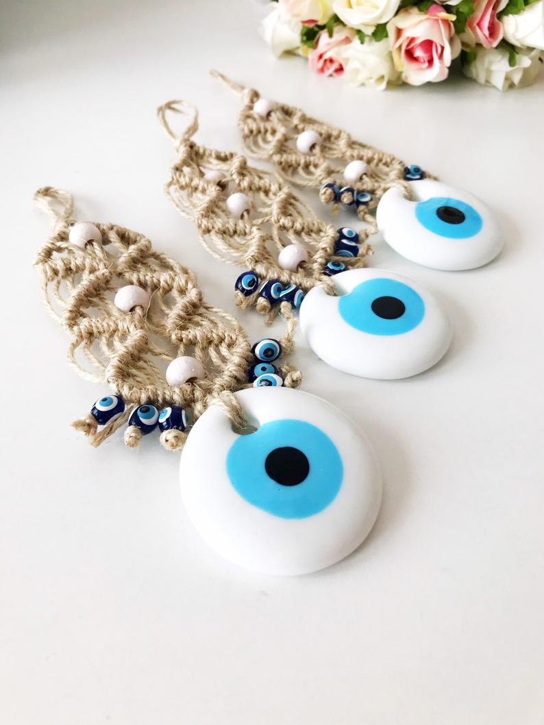 A beautiful collection of handmade evil eye wall hangings featuring various styles and colors, showcasing intricate macrame designs and vibrant beads.