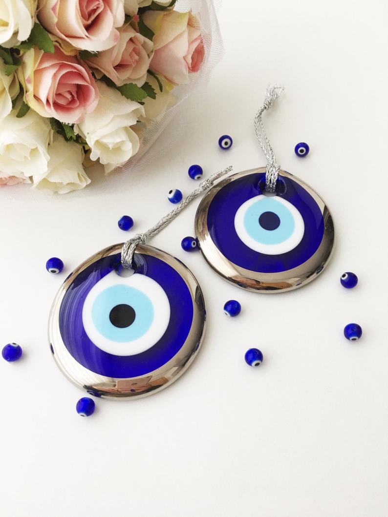 A beautiful collection of handmade evil eye wall hangings featuring various styles and colors, showcasing intricate macrame designs and vibrant beads.