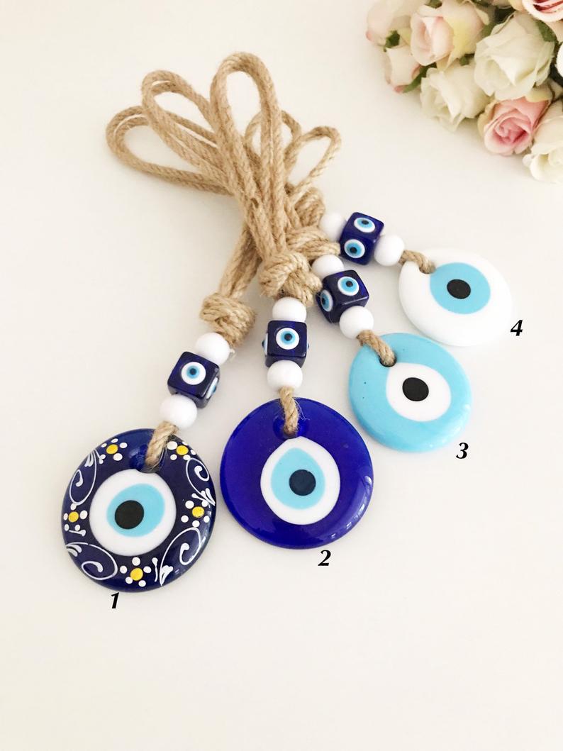 A beautiful collection of handmade evil eye wall hangings featuring various styles and colors, showcasing intricate macrame designs and vibrant beads.