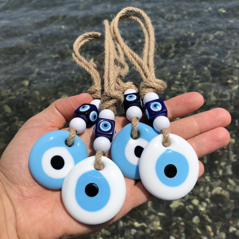 Handmade macrame wall hanging featuring white and blue evil eye beads, symbolizing protection and good luck.