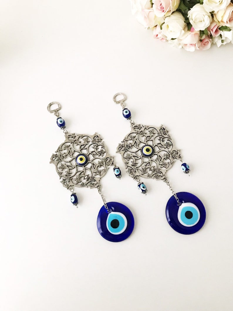 Evil Eye Blue Wall Decor featuring a round metal figure with a vibrant blue evil eye design, measuring 22cm in total length.