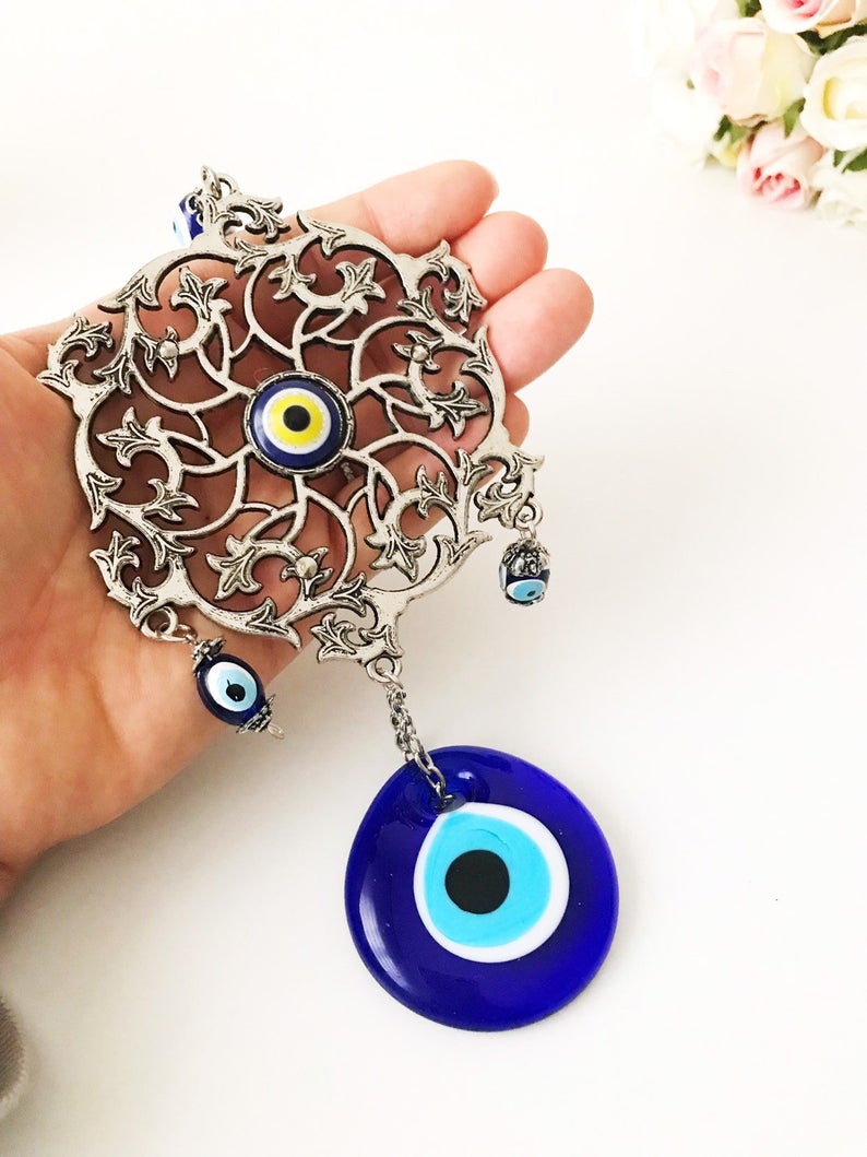 Evil Eye Blue Wall Decor featuring a round metal figure with a vibrant blue evil eye design, measuring 22cm in total length.