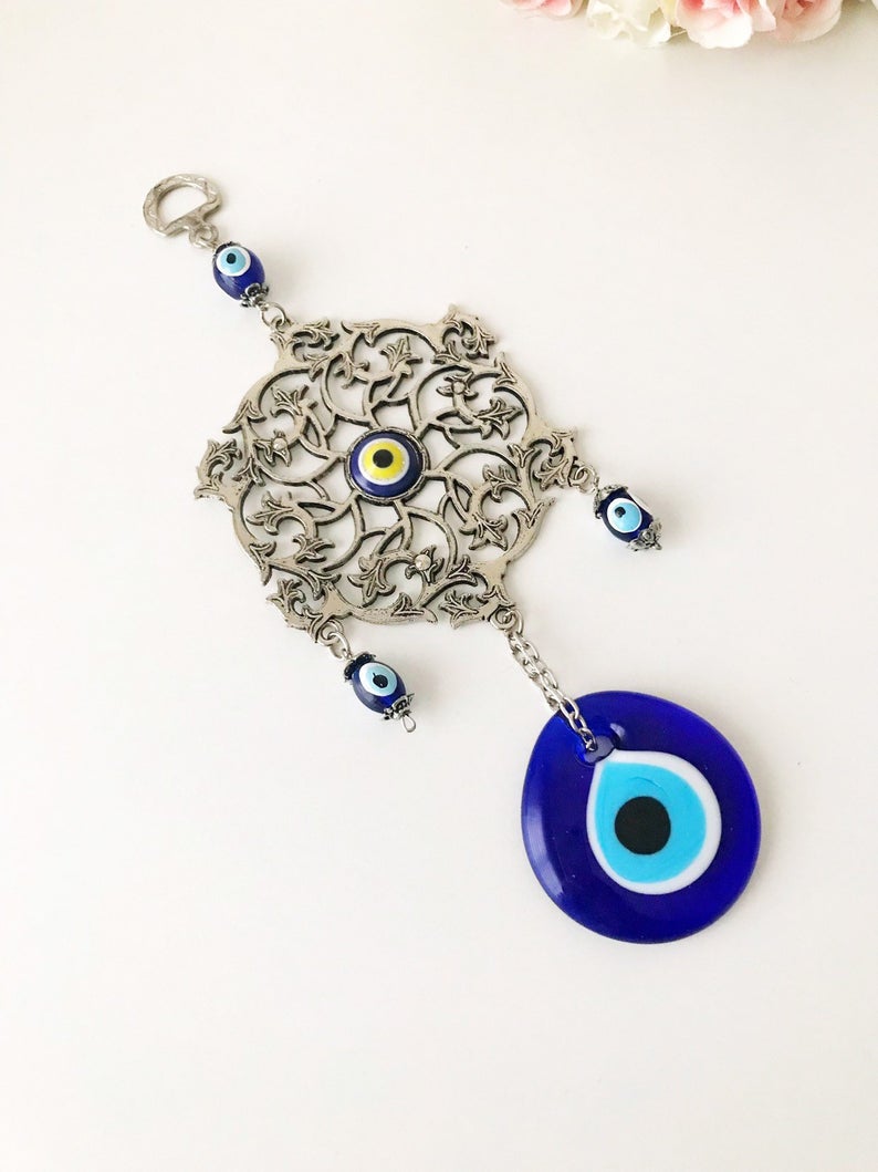 Evil Eye Blue Wall Decor featuring a round metal figure with a vibrant blue evil eye design, measuring 22cm in total length.